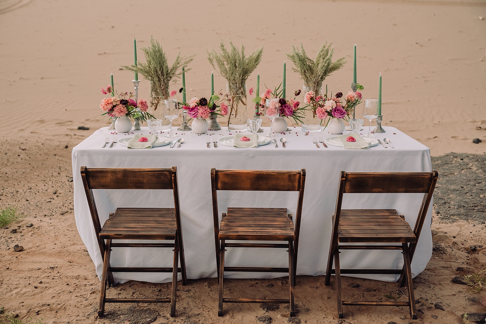 beach inspired elopement table decor with wooden chairs and pink florals