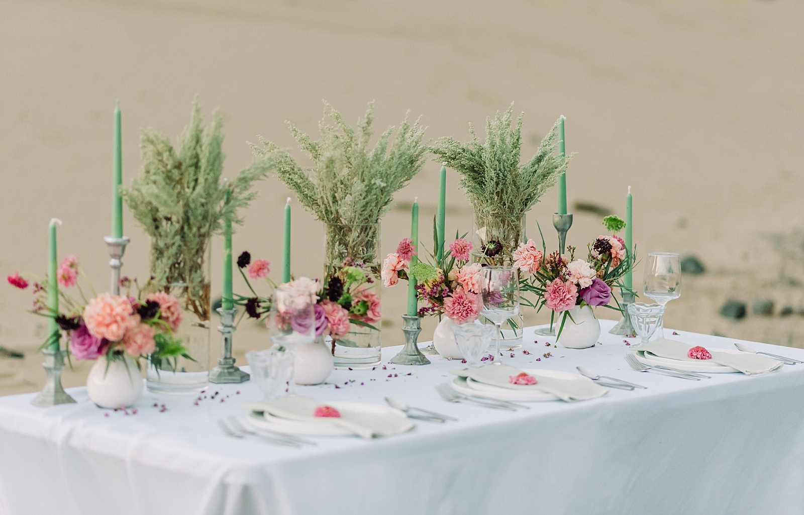 Beach inspired elopement table decor with pink flowers and green accents