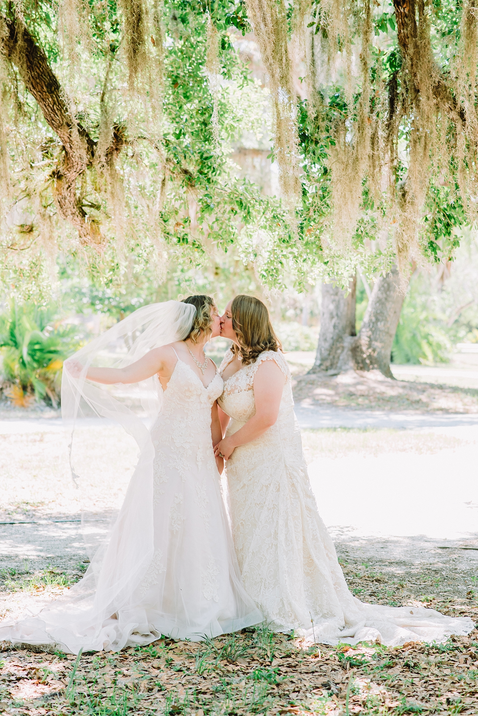 kissing lesbian couple in wedding dresses