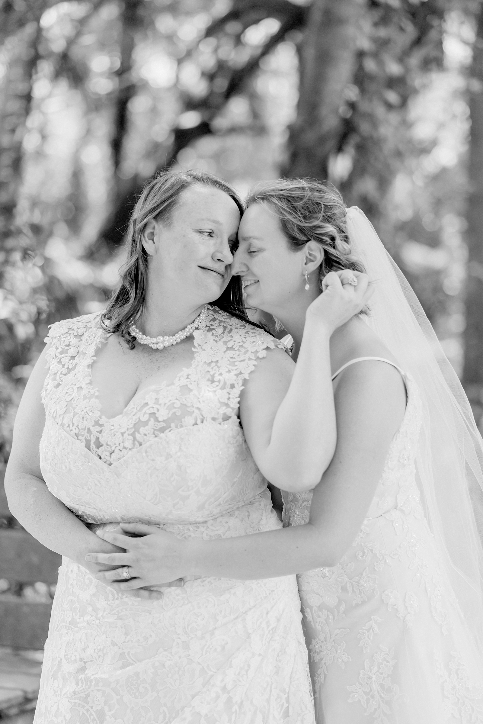 lesbian couple snuggles on wedding day