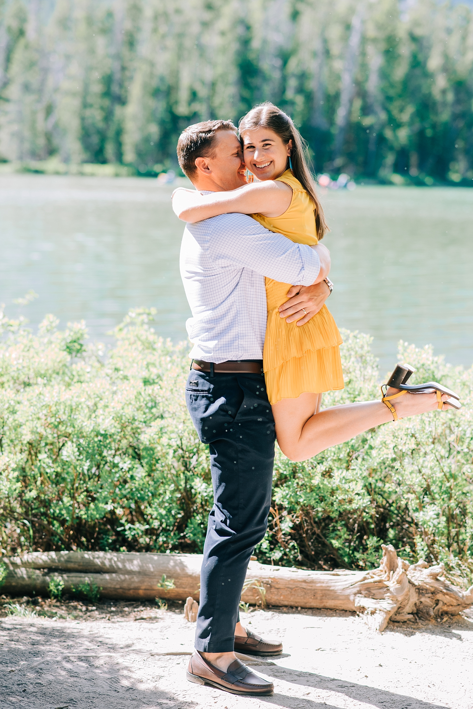 man holding woman as she jumps into his arms during their Jackson Hole honeymoon session at String Lake