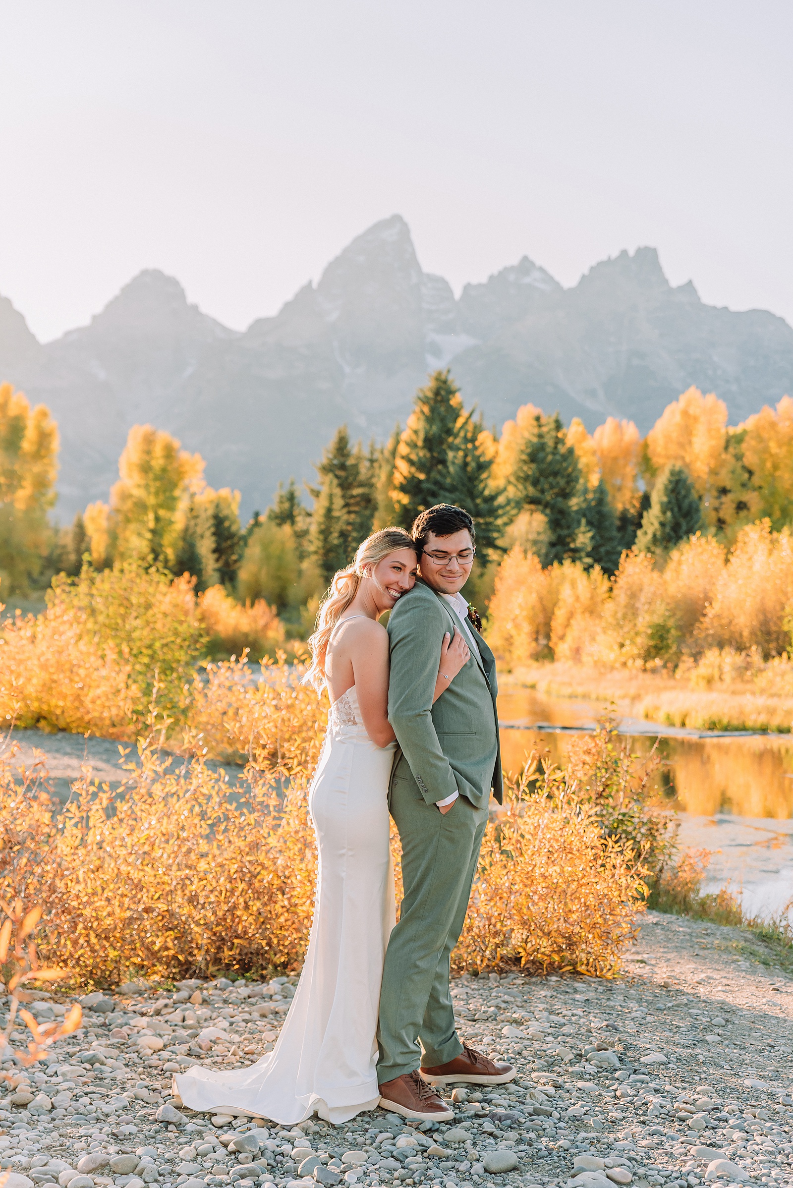 wedding couple posing in front of the grand teton mountains