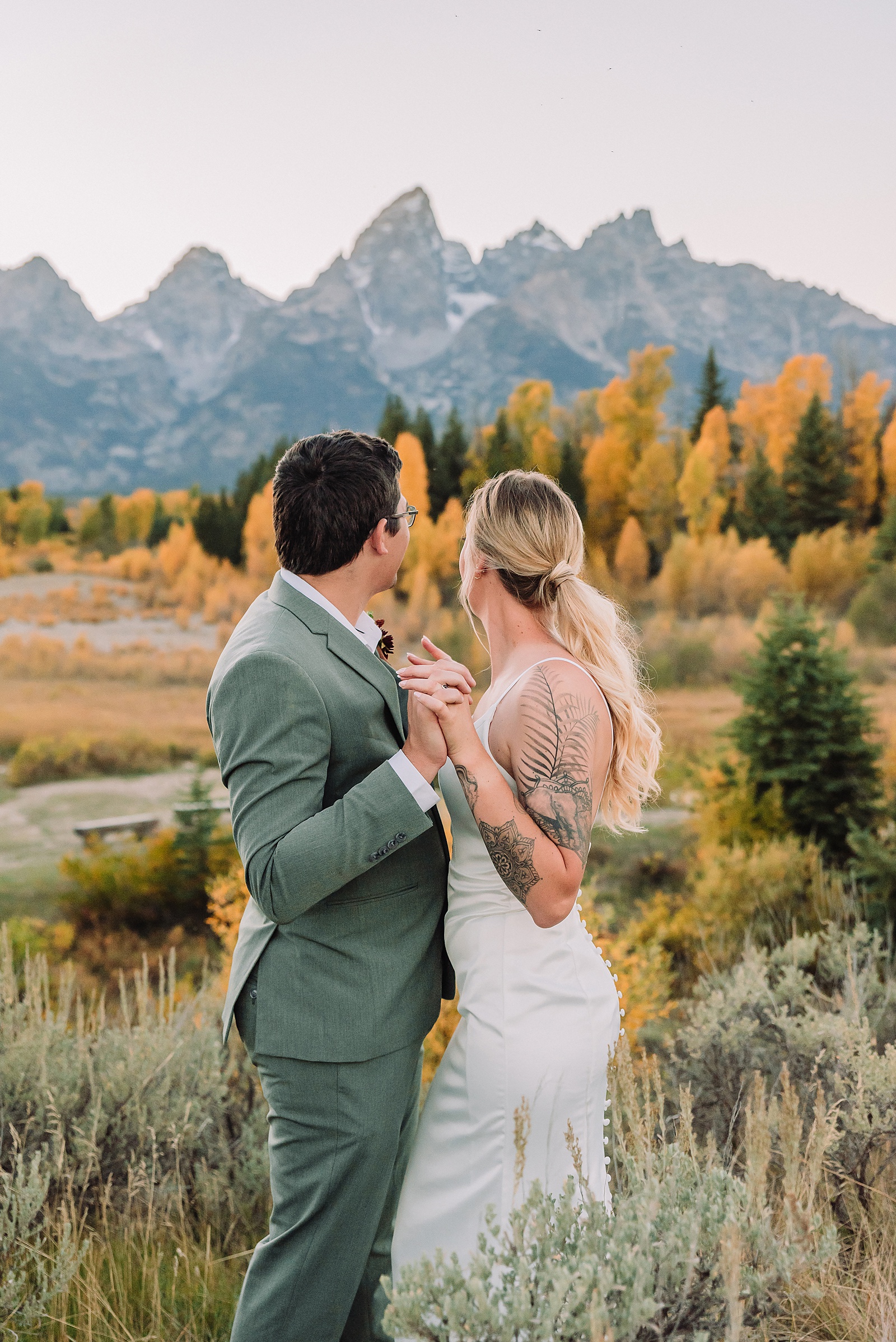 wedding couple posing in front of the grand teton mountains