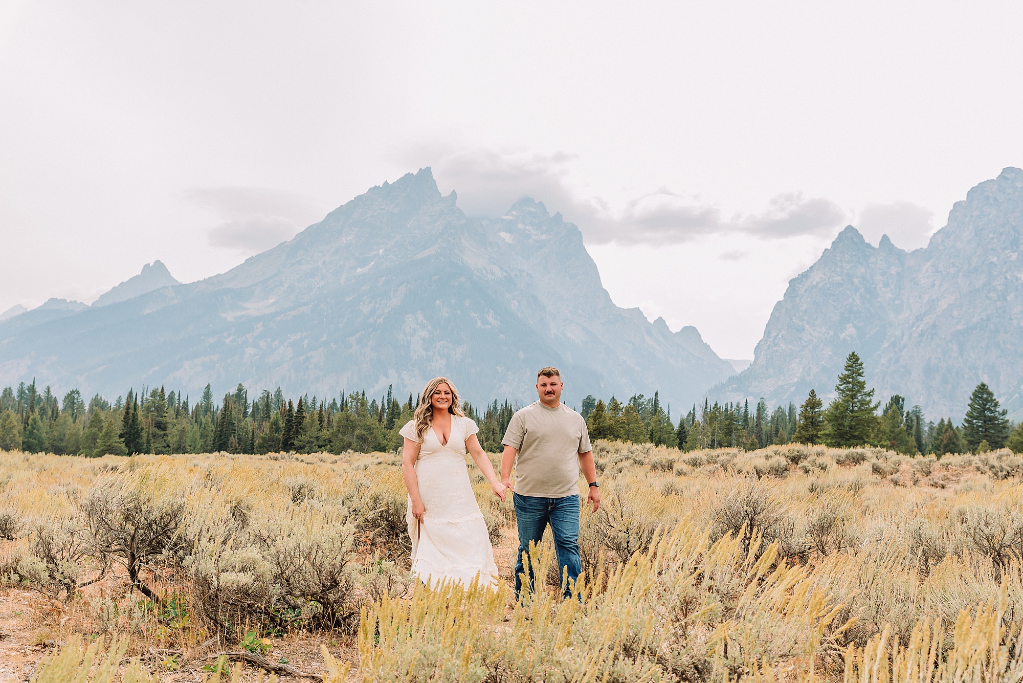 engaged couple stands in front of the Teton Mountains in romantic pose