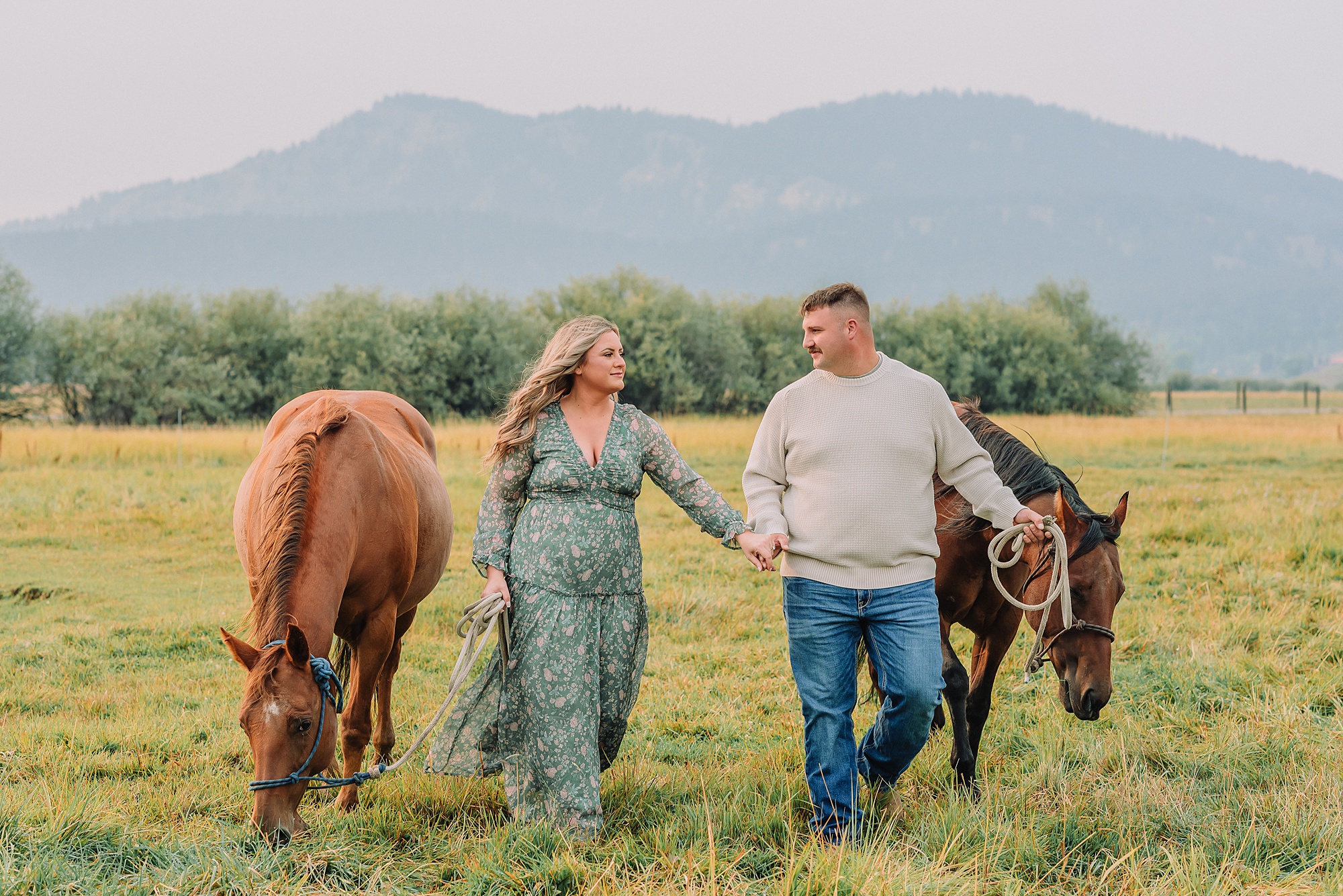 engaged Couple poses with horses at Diamond Cross Ranch