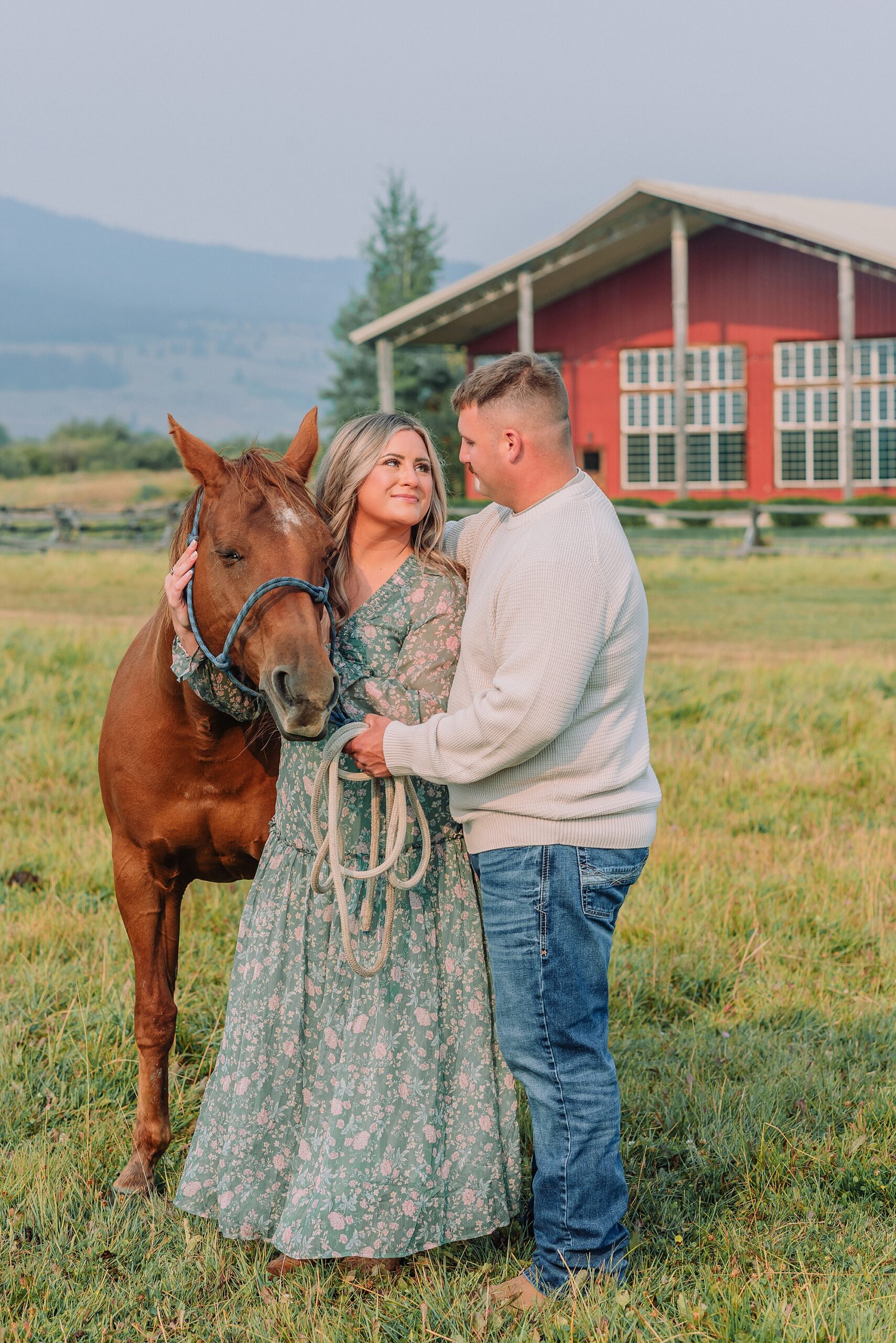 engaged Couple poses with horses at Diamond Cross Ranch