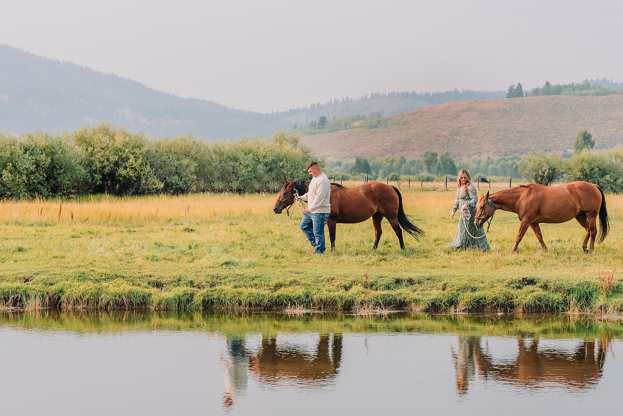 engaged Couple poses with horses at Diamond Cross Ranch