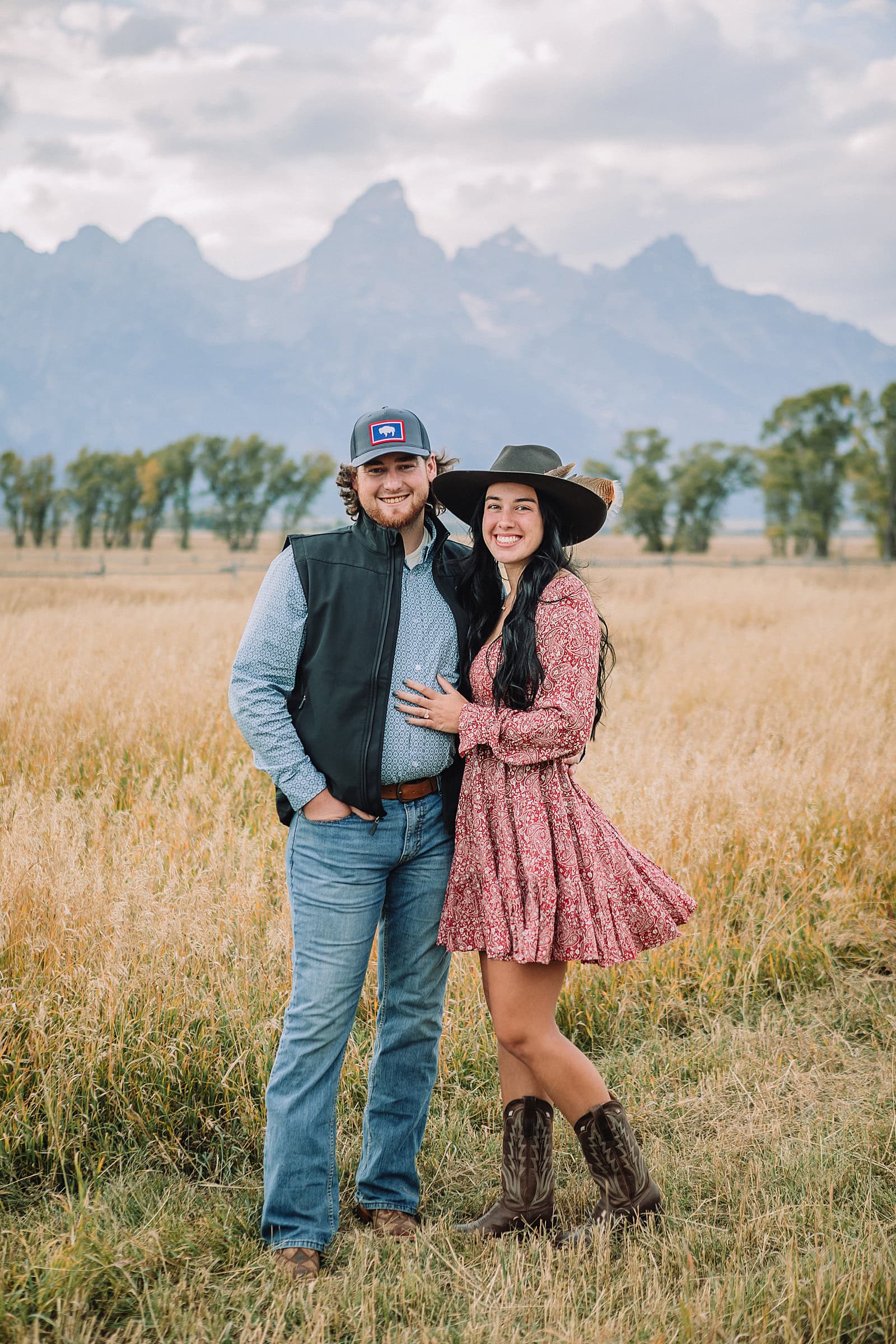 man proposes to girlfriend in fall mormon row proposal with golden grasses and the Teton Mountains