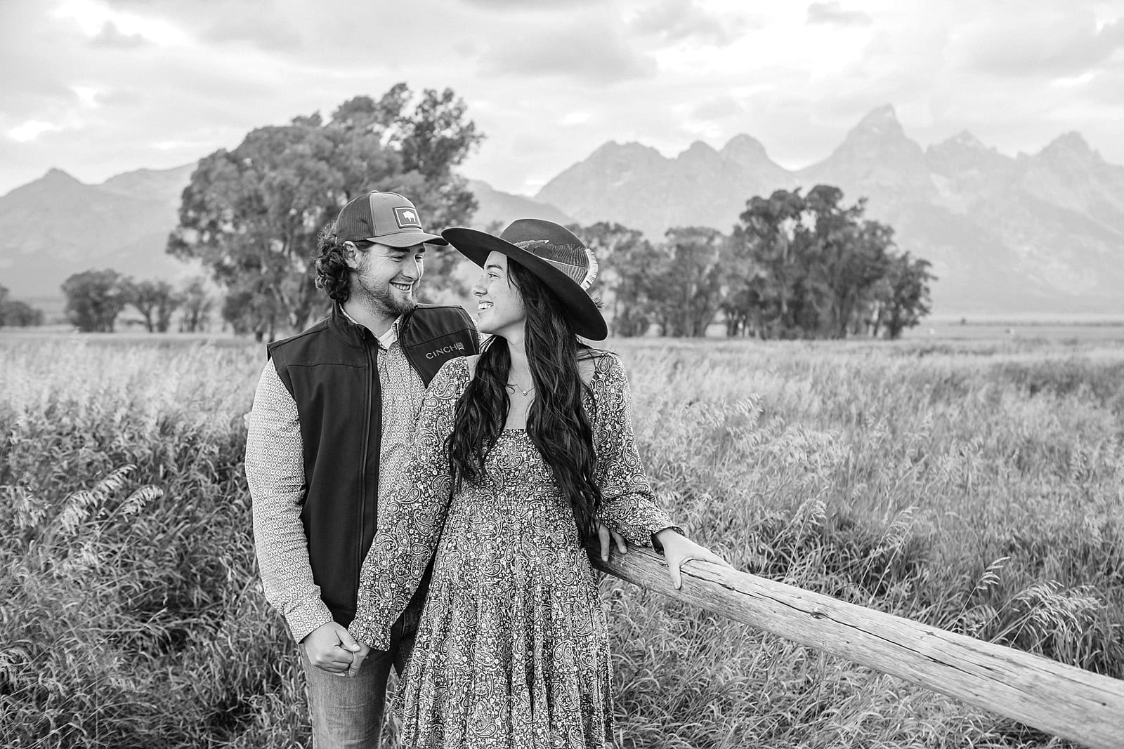 Engaged couple poses in front of the Teton Mountains and Moulton Barn
