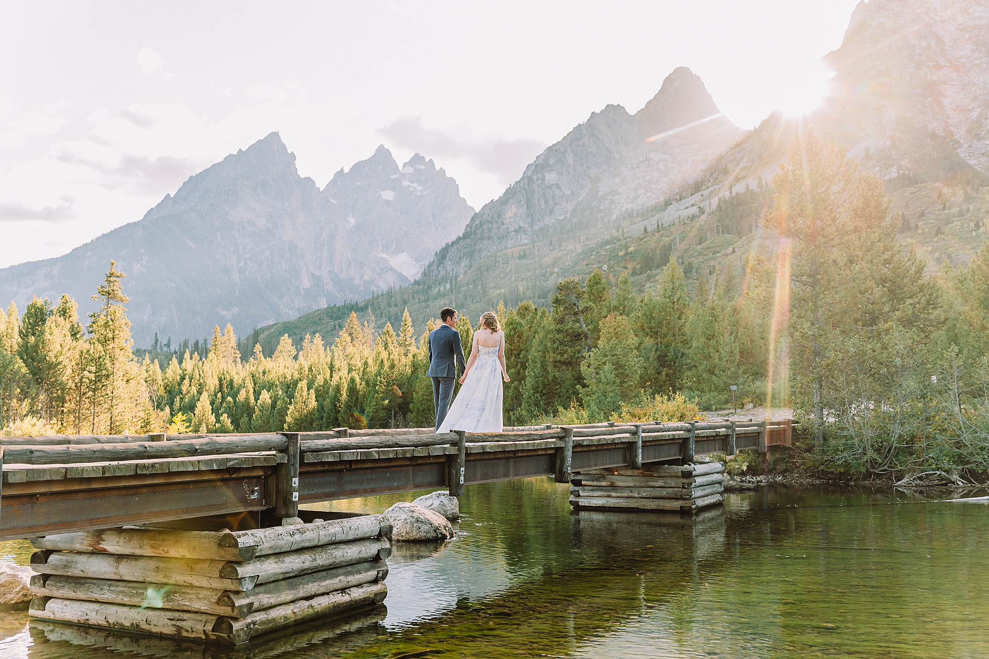 bride and groom walk toward the Teton mountains at String Lake