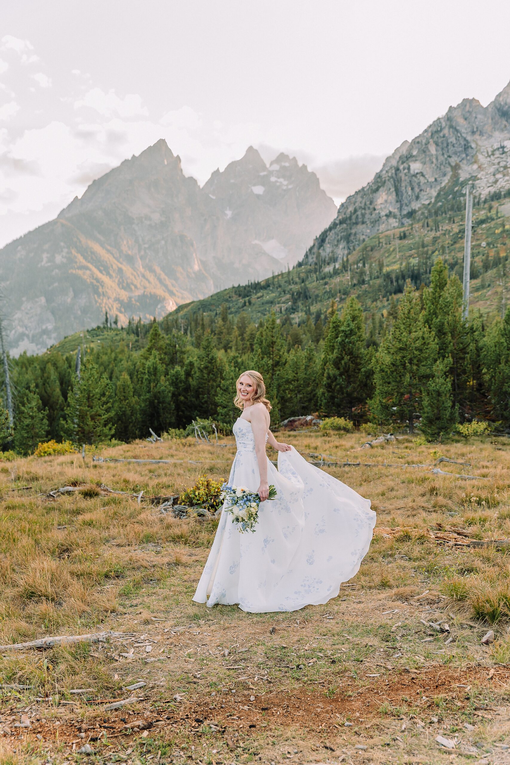 bride poses in wedding dress at String Lake in Jackson Hole