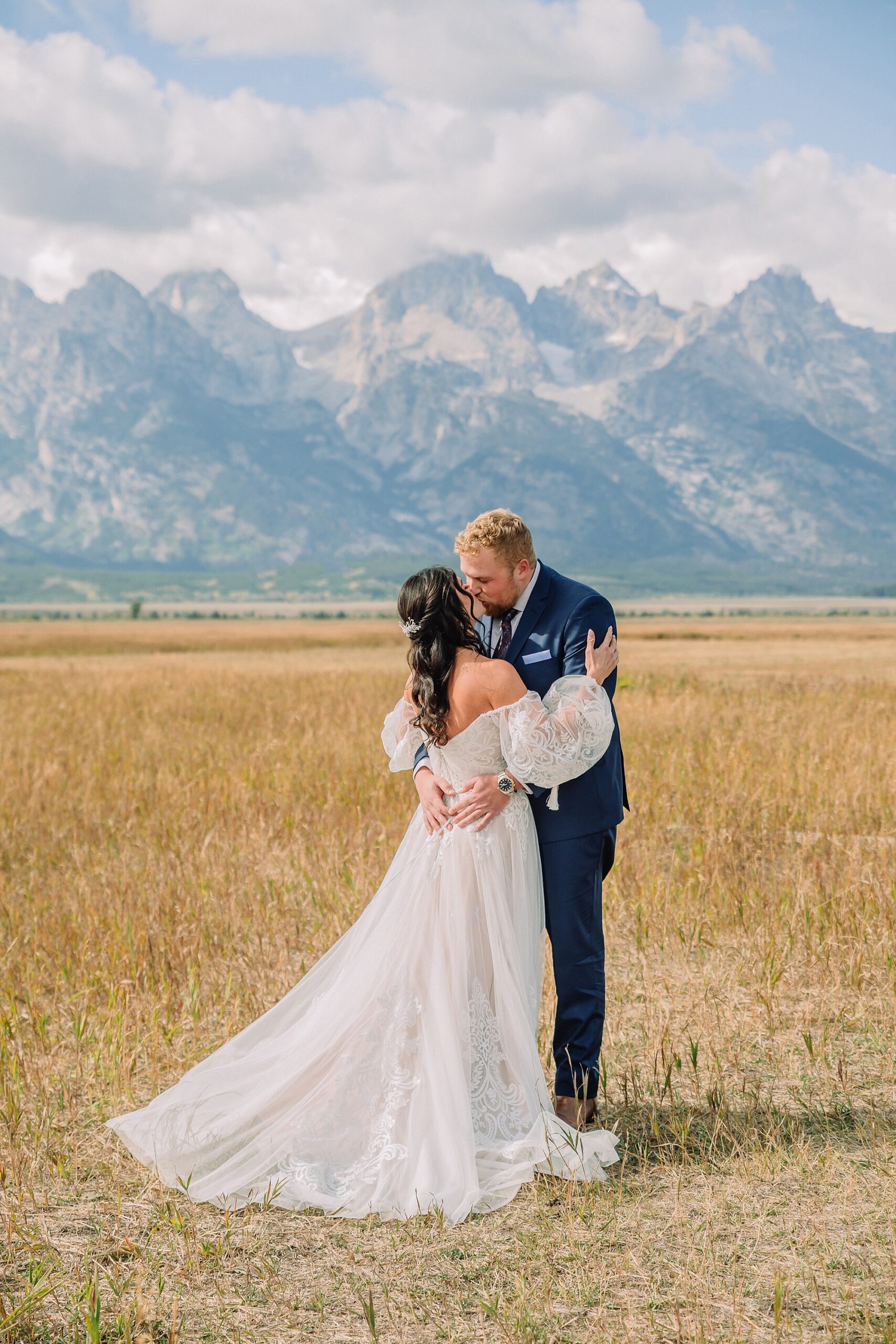 bride and groom share pre-ceremony first look in a field with the Teton mountains behind them