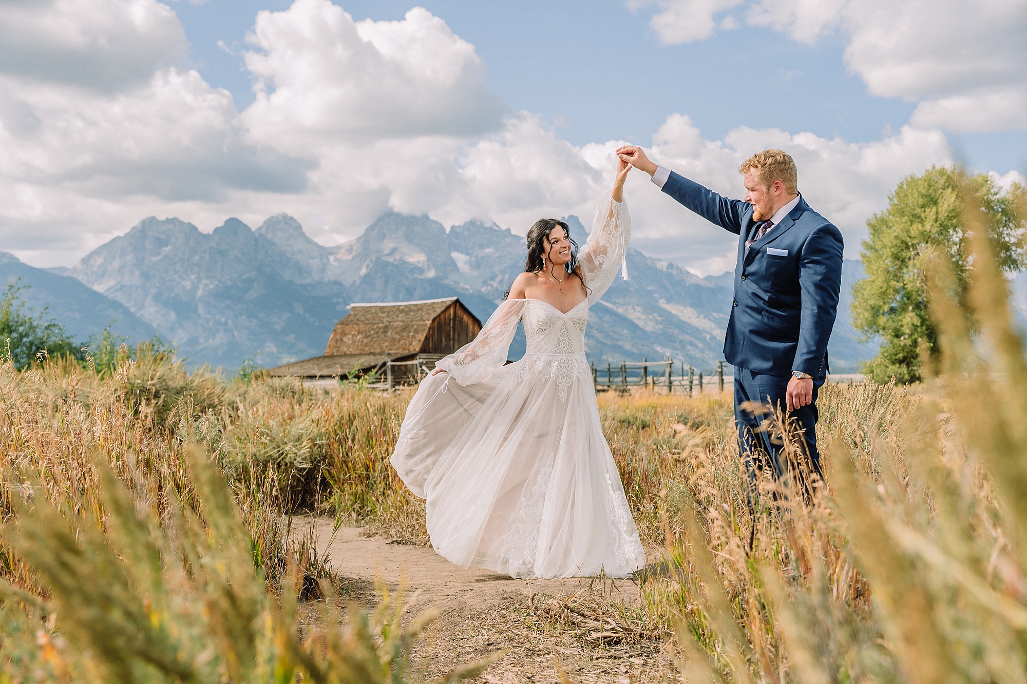 wedding couple dances in front of the mormon row barn, John Moulton barn and the Tetons
