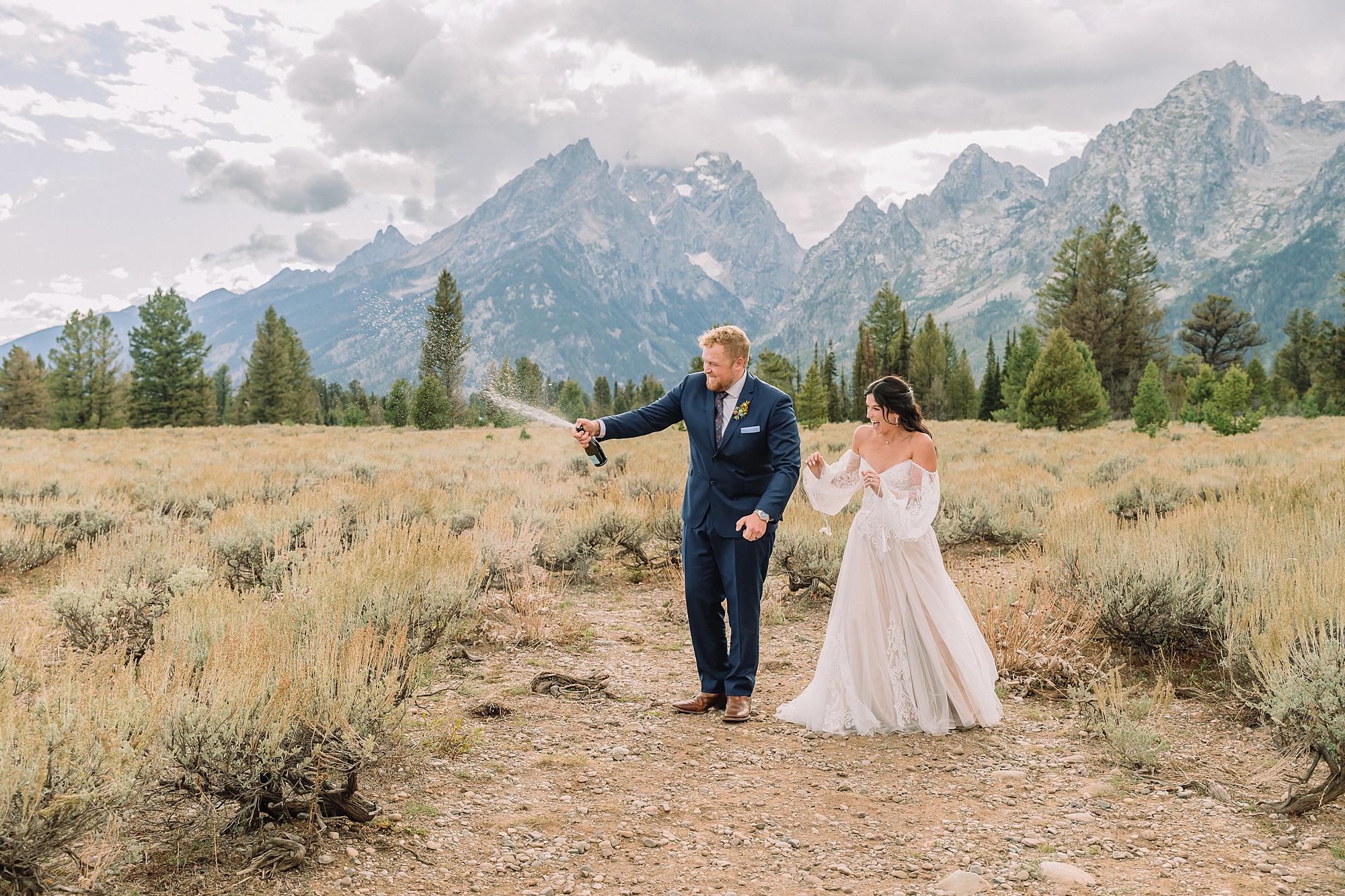 Bride and Groom pop champagne for a toast at Mountain View Turnout in Grand Teton National Park