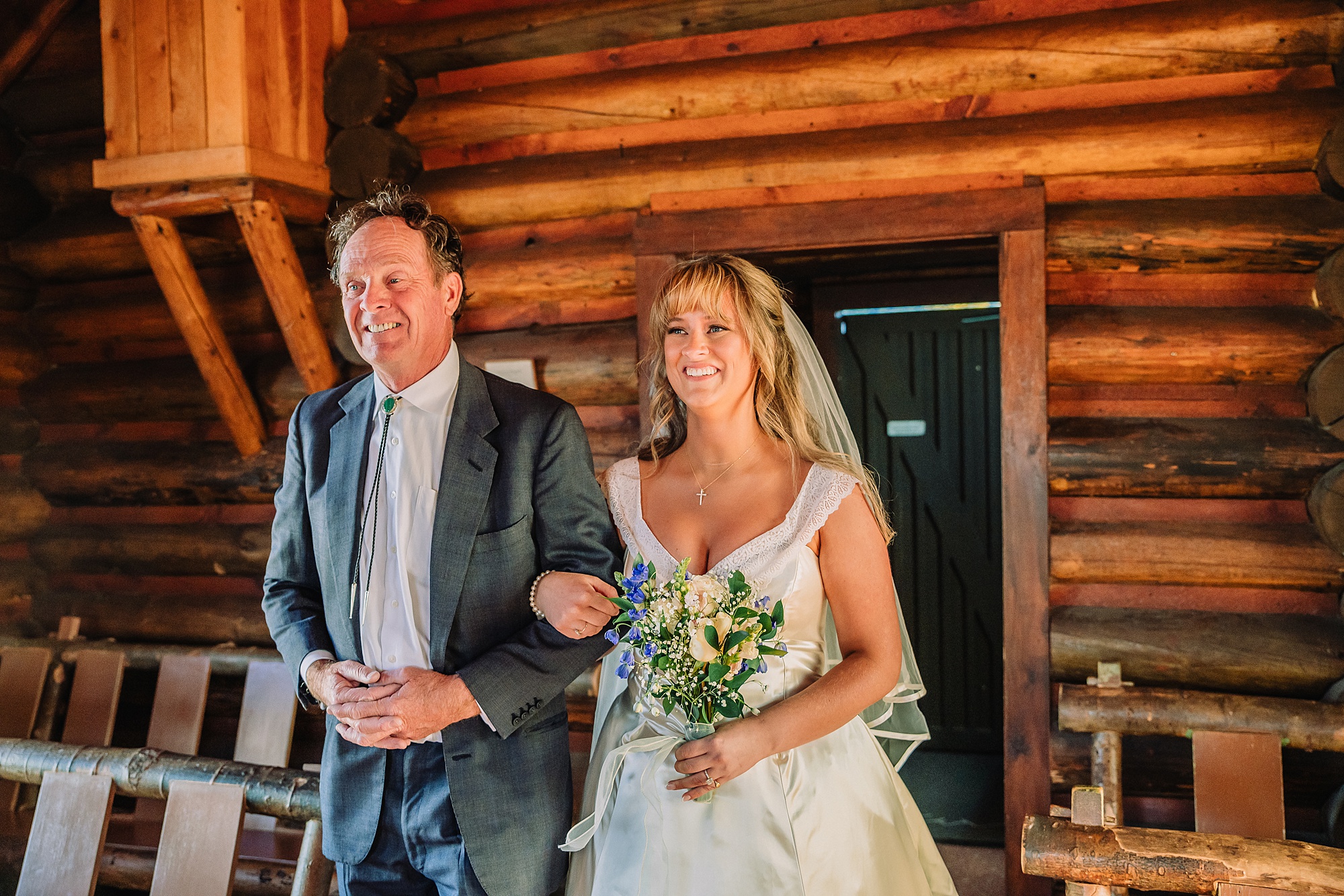 Grand Teton National Park micro wedding Chapel of the Transfiguration bride and groom portraits bride groom cowboy hat bolo tie mountain wedding Chapel of the Transfiguration bell ringing celebration Jackson Hole Wedding Photographers rustic chapel wedding log cabin ceremony