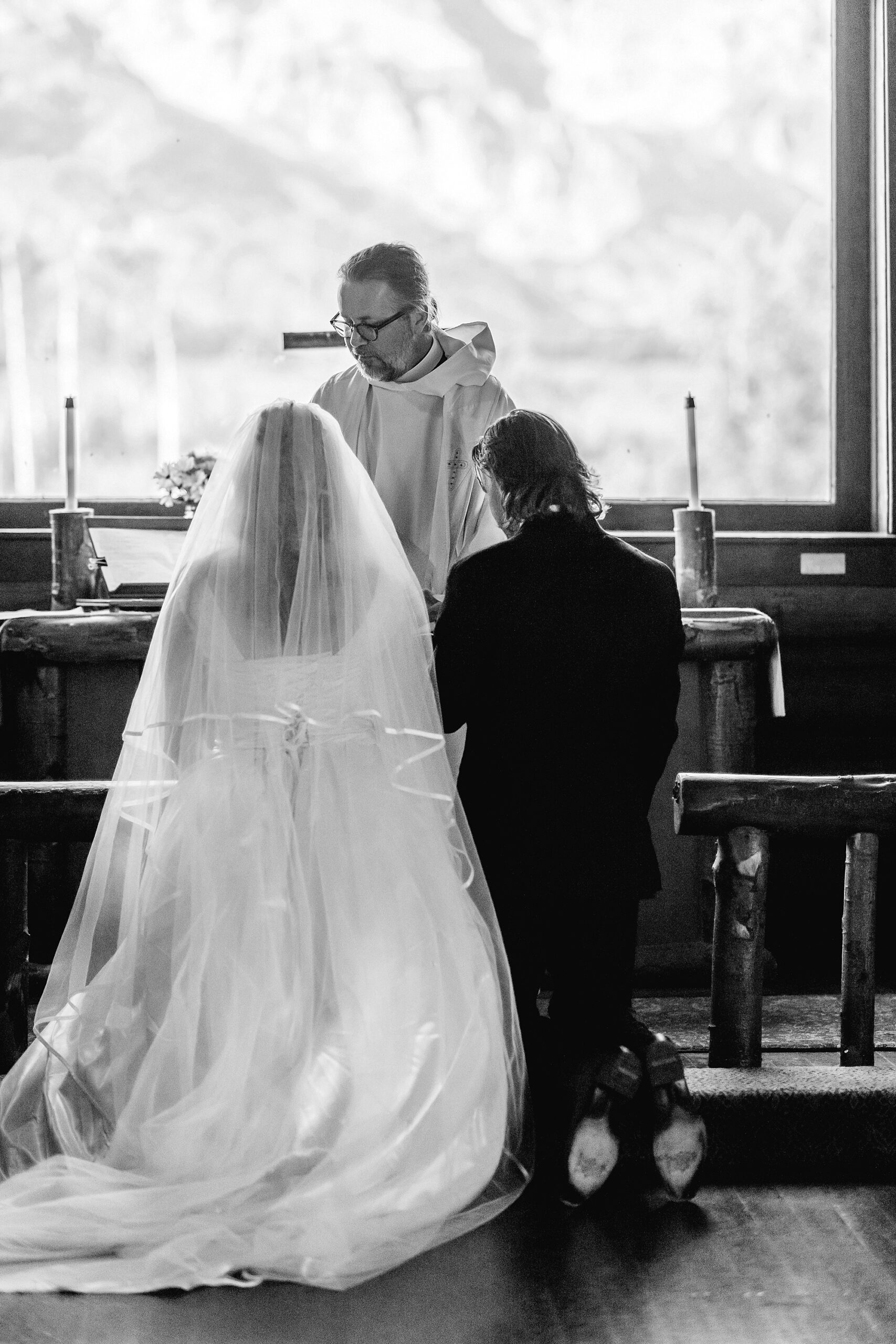 Grand Teton National Park micro wedding Chapel of the Transfiguration bride and groom portraits bride groom cowboy hat bolo tie mountain wedding Chapel of the Transfiguration bell ringing celebration Jackson Hole Wedding Photographers rustic chapel wedding log cabin ceremony