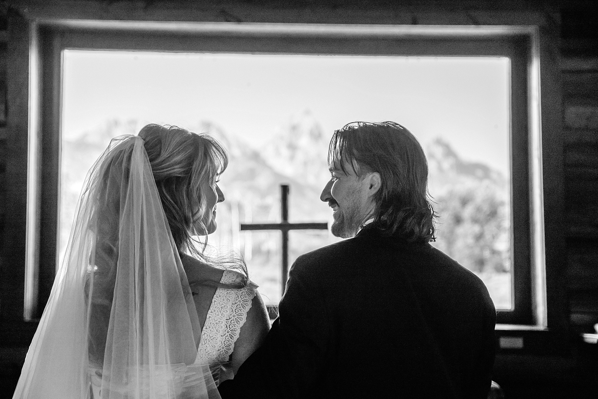 Grand Teton National Park micro wedding Chapel of the Transfiguration bride and groom portraits bride groom cowboy hat bolo tie mountain wedding Chapel of the Transfiguration bell ringing celebration Jackson Hole Wedding Photographers rustic chapel wedding log cabin ceremony