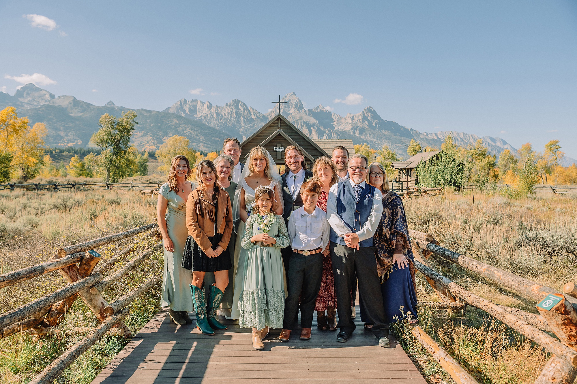Grand Teton National Park micro wedding Chapel of the Transfiguration bride and groom portraits bride groom cowboy hat bolo tie mountain wedding Chapel of the Transfiguration bell ringing celebration Jackson Hole Wedding Photographers rustic chapel wedding log cabin ceremony