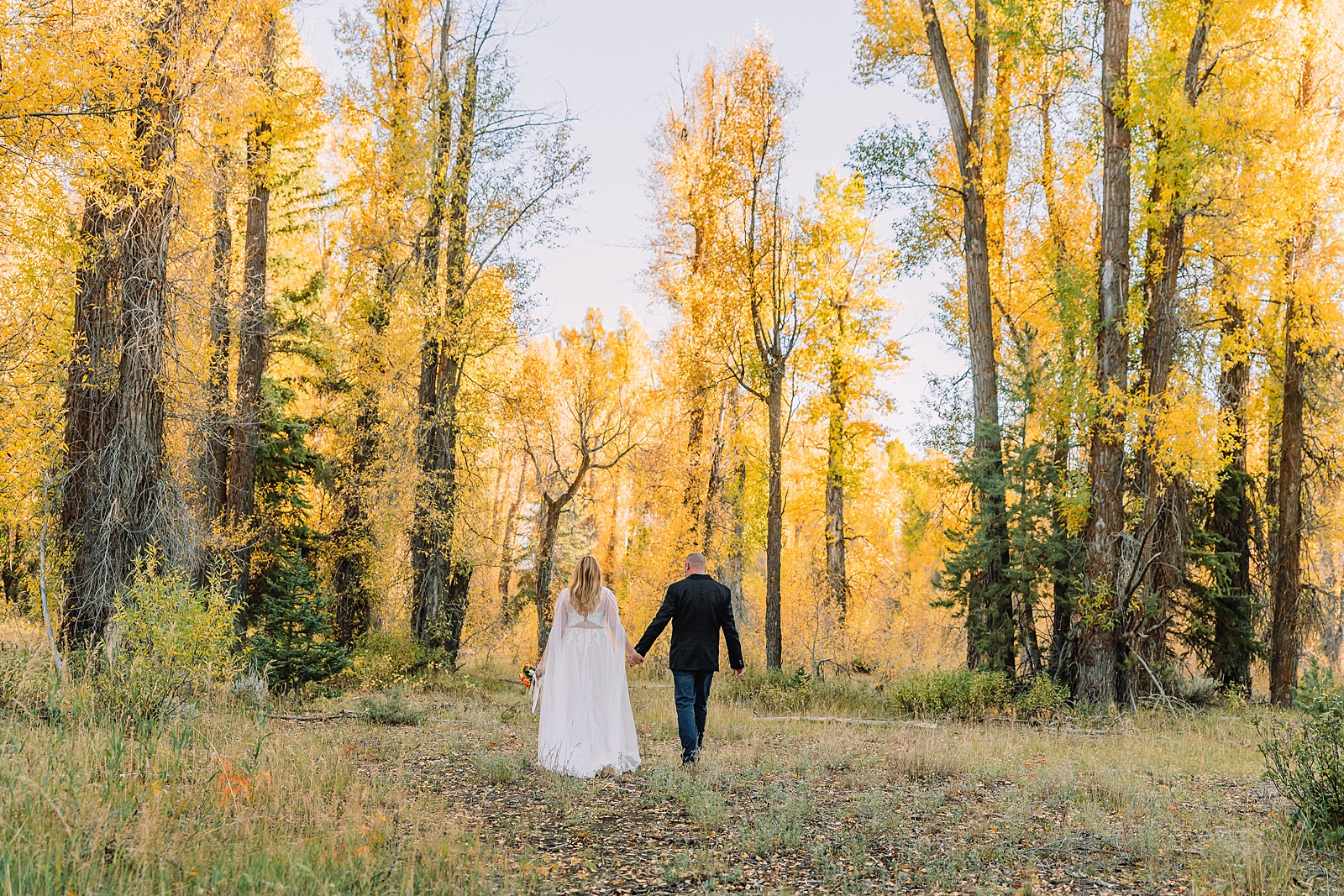 Jackson Hole honeymoon wedding photos Schwabacher Landing wedding portraits Snake River wedding photography September mountain wedding photos beaded wedding dress golden hour western groom style wedding photos Teton mountain wedding portraits sheer cape wedding dress photography