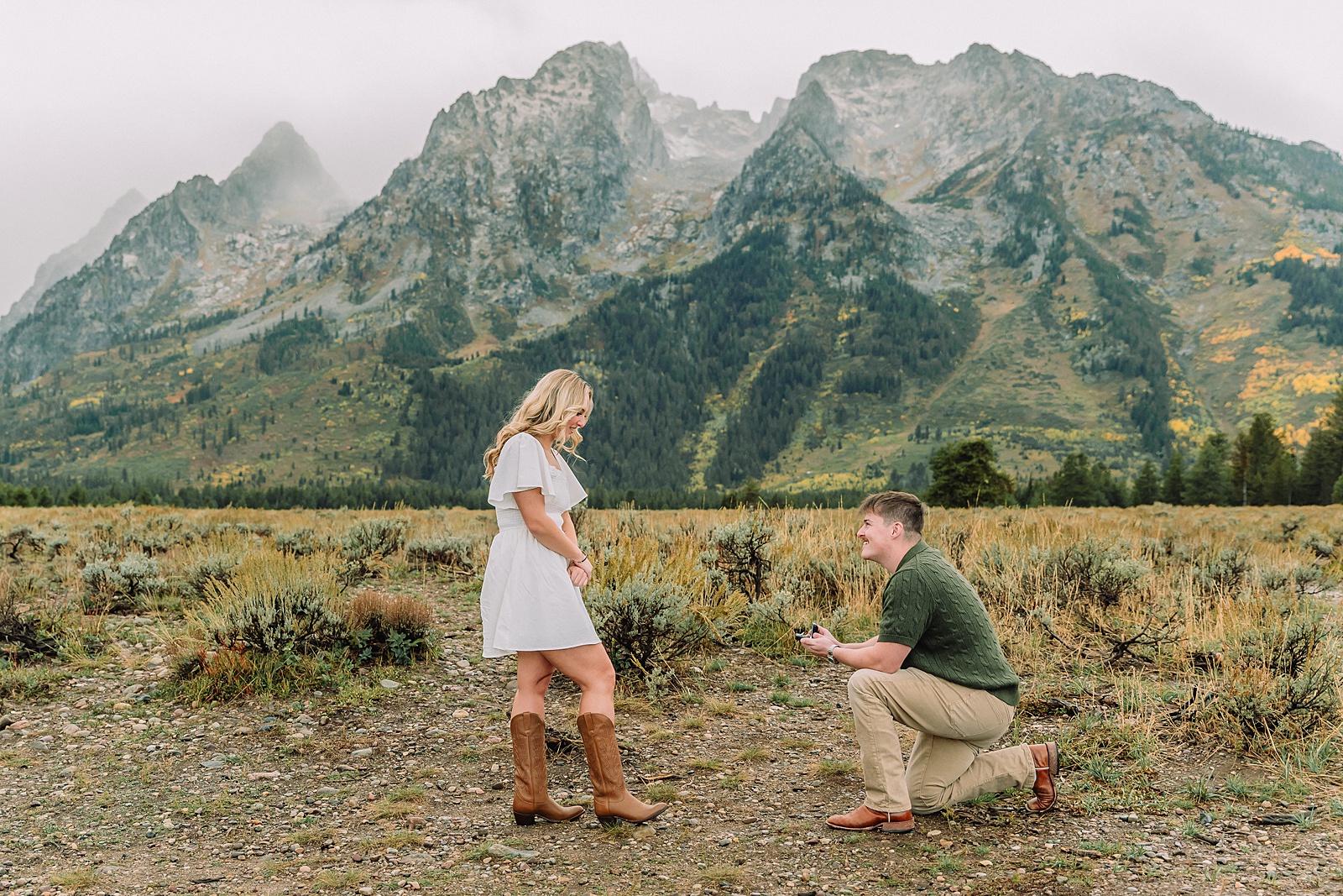 Grand Teton proposal photos at Cathedral View Turnout in the rain Cathedral View Turnout proposal photographer Jackson Hole Wyoming Genuine proposal reaction photos Grand Teton sagebrush field Moody stormy mountain proposal photography Jackson Hole jackson hole proposal photographer