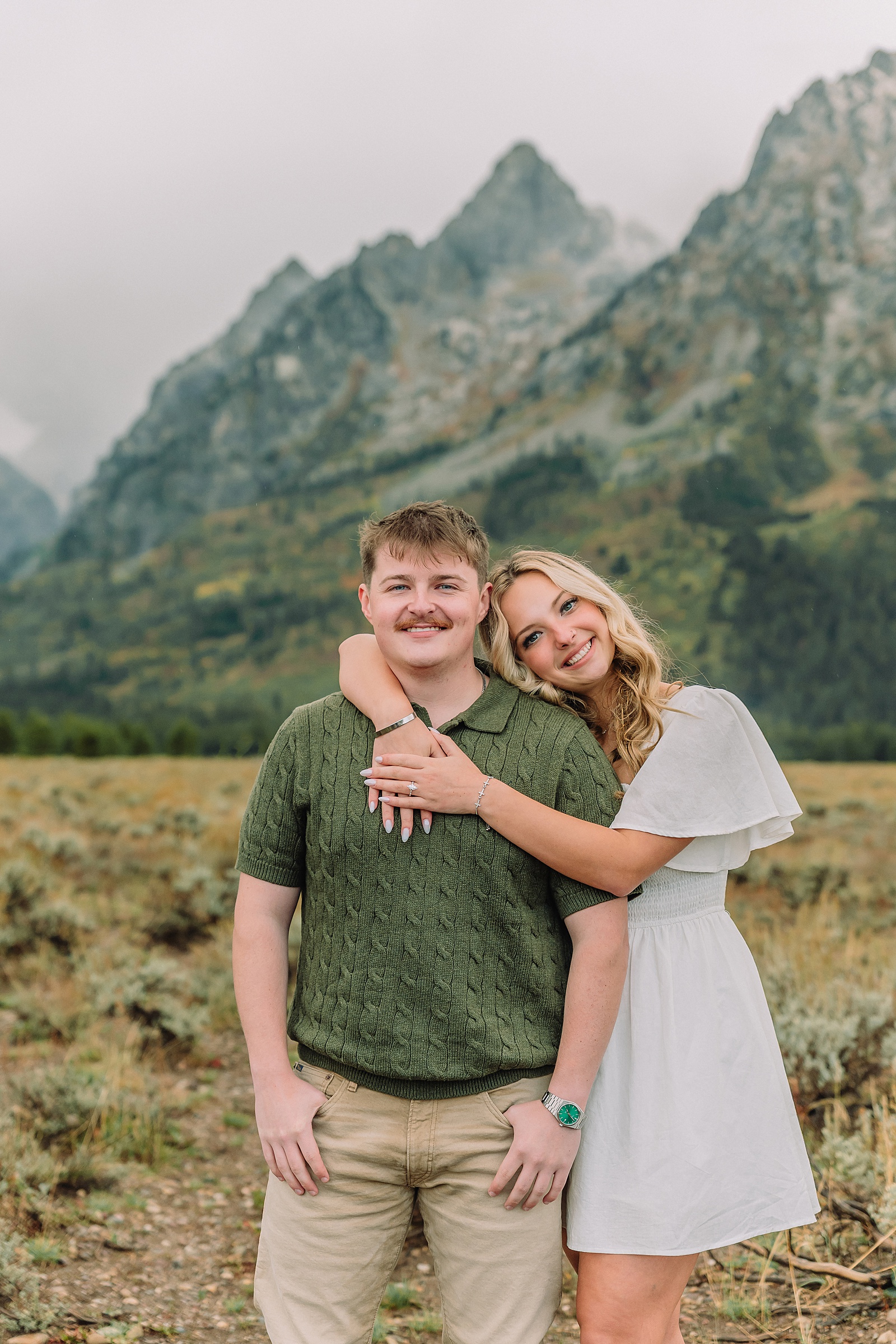 Grand Teton proposal photos at Cathedral View Turnout in the rain Cathedral View Turnout proposal photographer Jackson Hole Wyoming Genuine proposal reaction photos Grand Teton sagebrush field Moody stormy mountain proposal photography Jackson Hole jackson hole proposal photographer