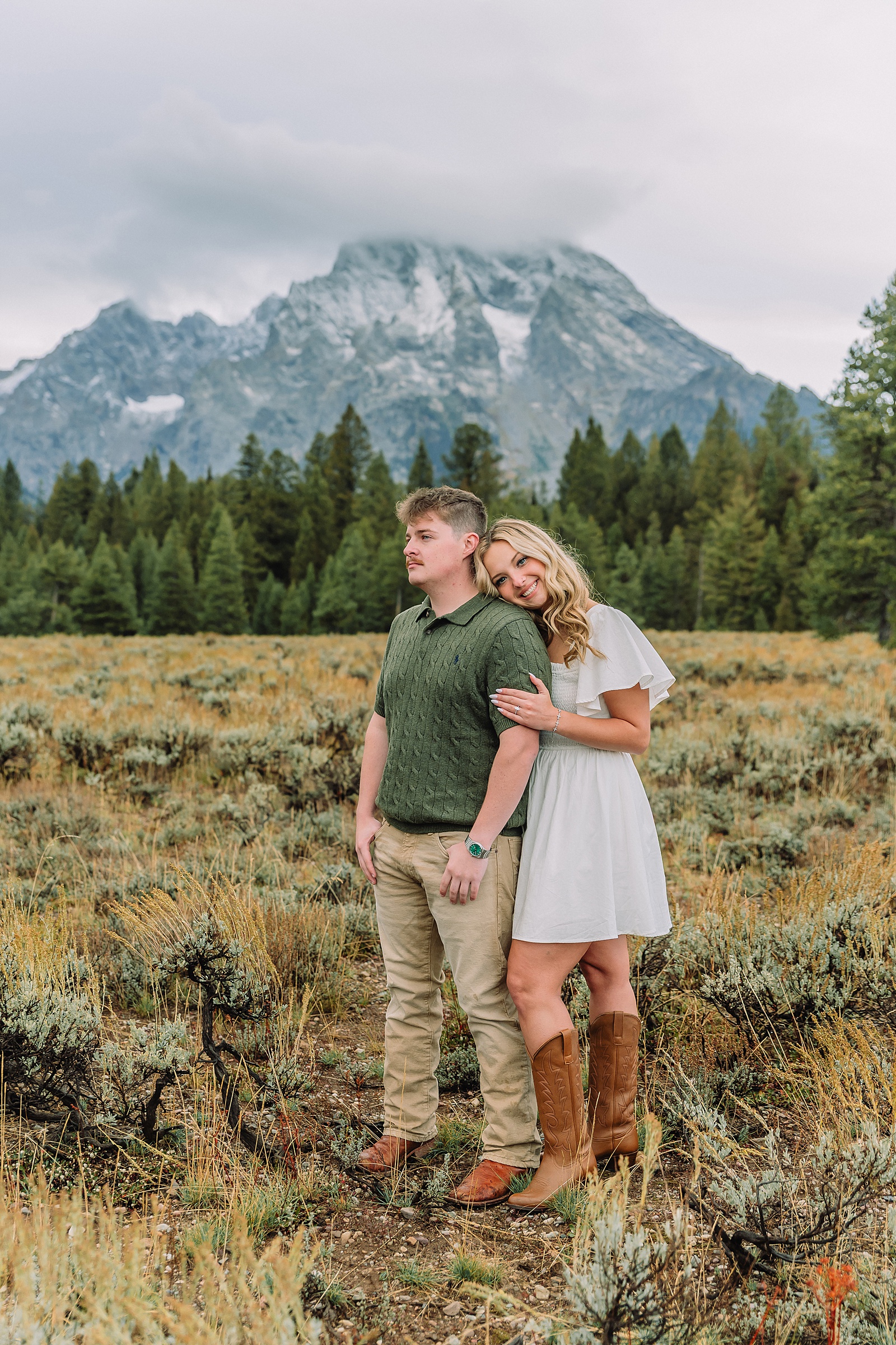 Grand Teton proposal photos at Cathedral View Turnout in the rain Cathedral View Turnout proposal photographer Jackson Hole Wyoming Genuine proposal reaction photos Grand Teton sagebrush field Moody stormy mountain proposal photography Jackson Hole jackson hole proposal photographer