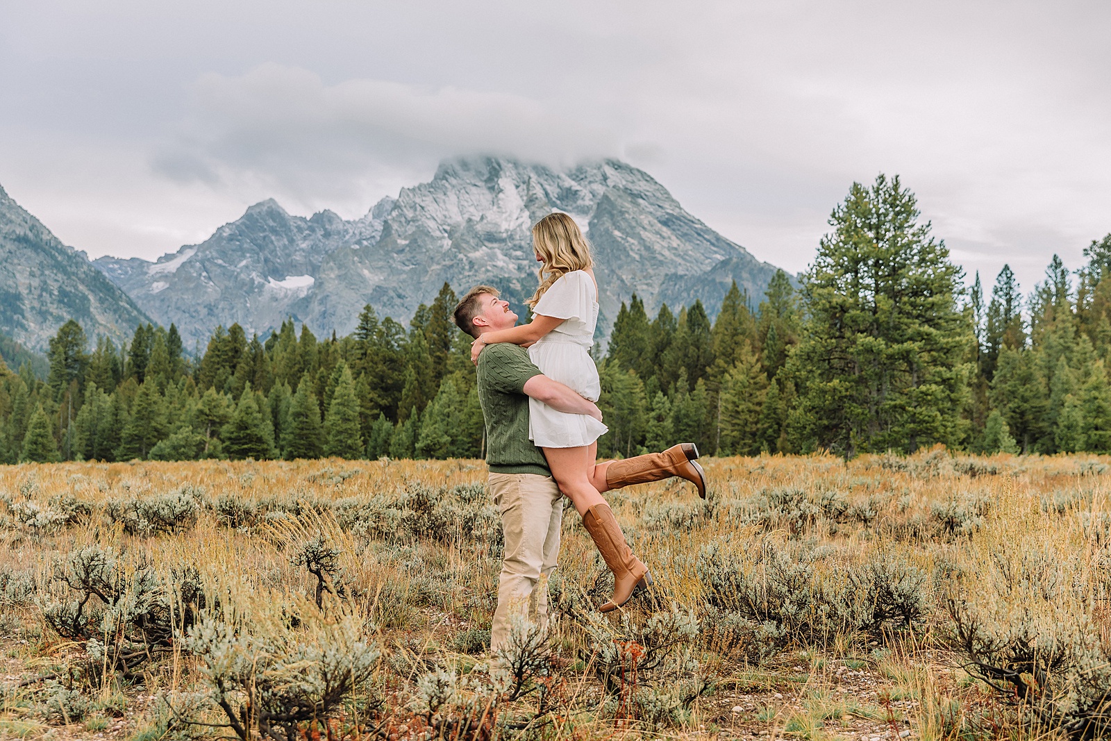 Grand Teton proposal photos at Cathedral View Turnout in the rain Cathedral View Turnout proposal photographer Jackson Hole Wyoming Genuine proposal reaction photos Grand Teton sagebrush field Moody stormy mountain proposal photography Jackson Hole jackson hole proposal photographer