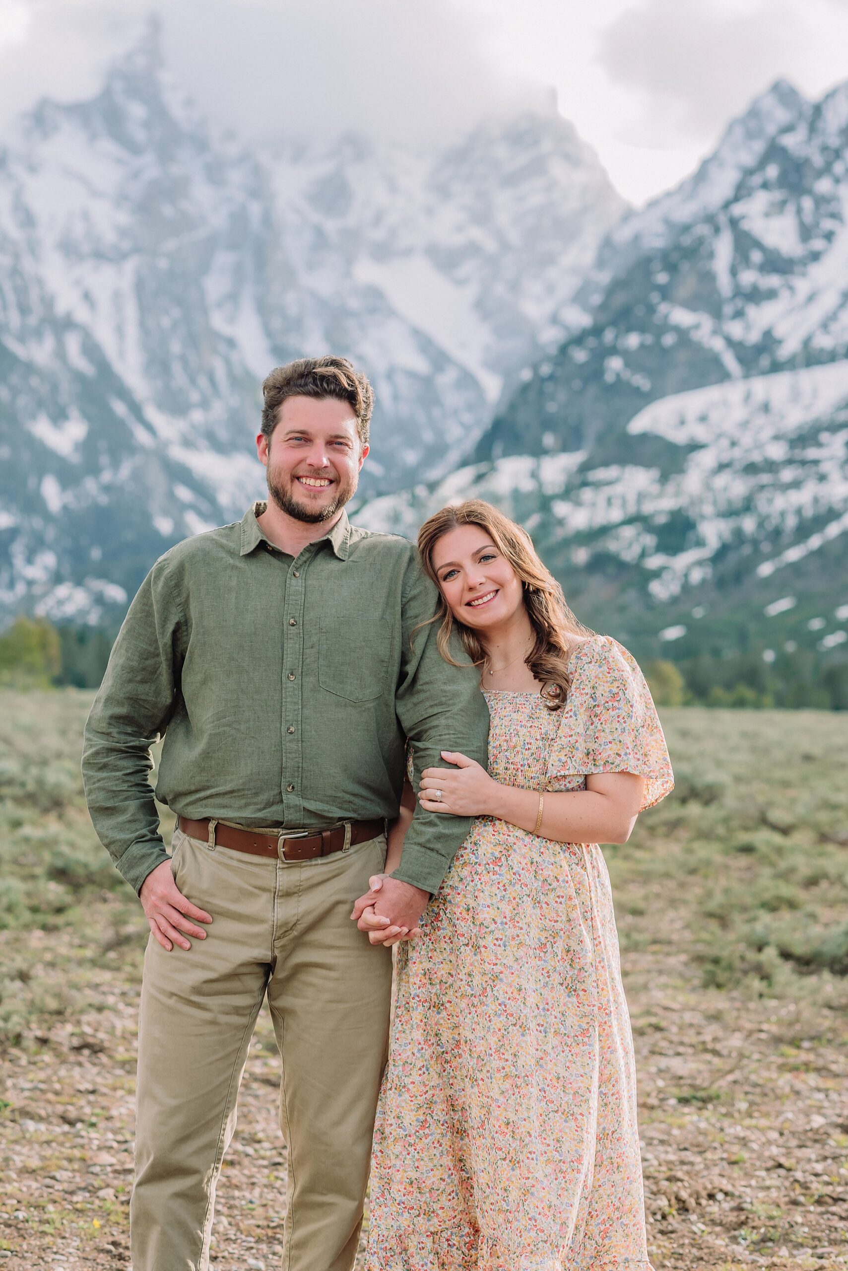 Jackson Hole babymoon maternity photos at Cathedral View Turnout Grand Teton National Park maternity session in spring Cathedral View Turnout couple photos snow capped peaks Flowery maternity dress mountain photography Jackson Hole Jackson Hole Maternity Photographer