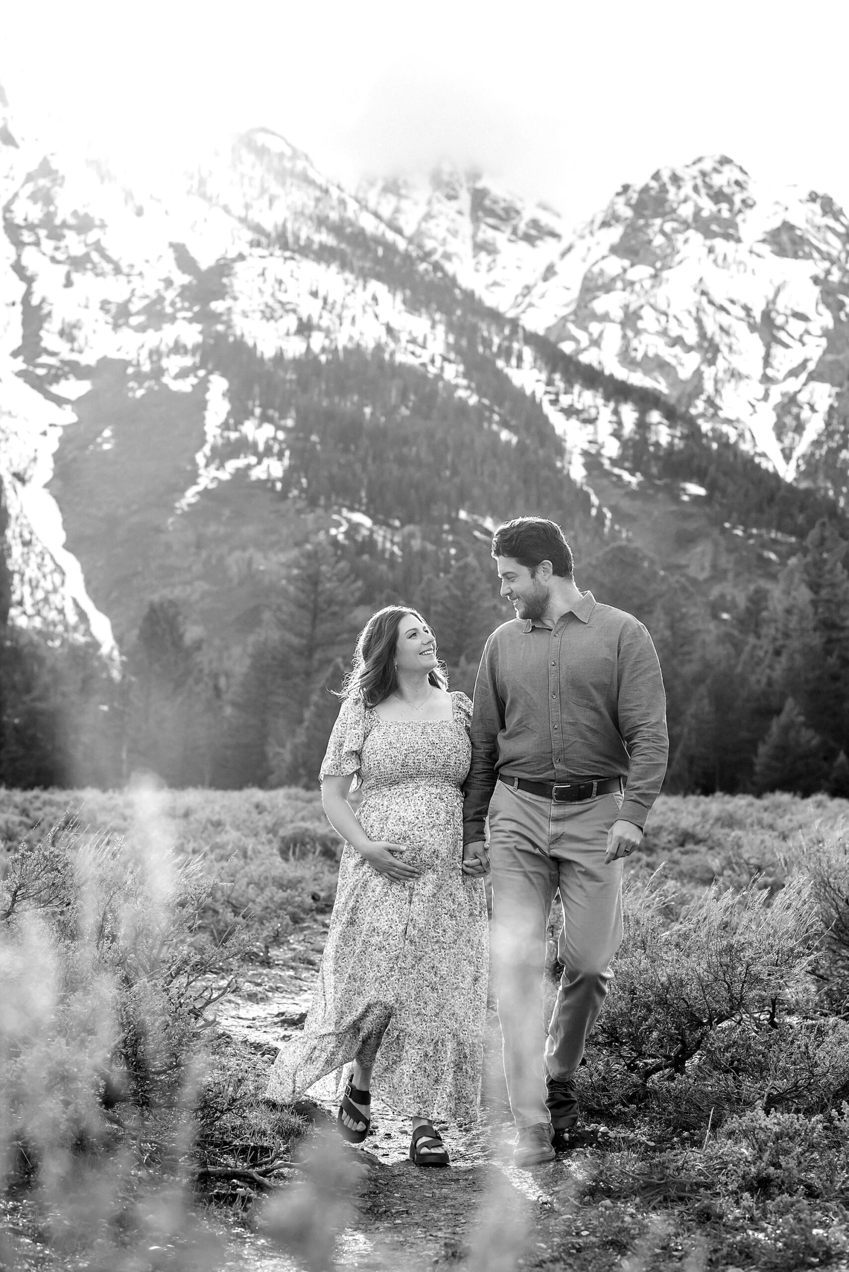 Jackson Hole babymoon maternity photos at Cathedral View Turnout Grand Teton National Park maternity session in spring Cathedral View Turnout couple photos snow capped peaks Flowery maternity dress mountain photography Jackson Hole Jackson Hole Maternity Photographer