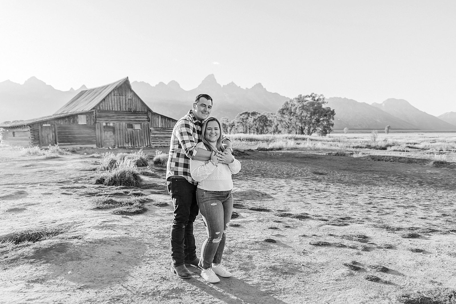 Mormon Row barn proposal photography Jackson Hole Wyoming Sunset engagement photos at TA Moulton Barn Surprise proposal photographer Grand Teton National Park Golden hour mountain proposal photography Jackson Hole Authentic couple portraits Mormon Row historic barn