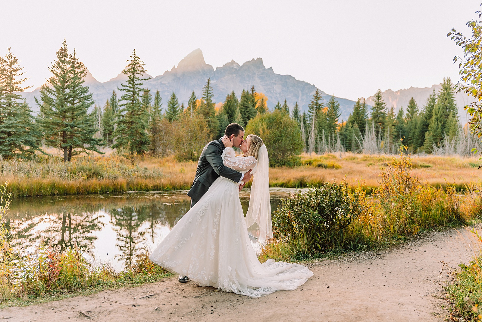 fall bridal portraits at Schwabacher Landing Jackson Hole Grand Teton National Park engagement photos String Lake bride in lace wedding dress with mountain backdrop Wyoming Schwabacher Landing fall color wedding photography Jackson Hole couple portraits with Snake River reflection bride and groom in fall foliage Grand Teton Wyoming rust orange tie groom wedding portraits Jackson Hole fall September engagement photos String Lake Teton National Park