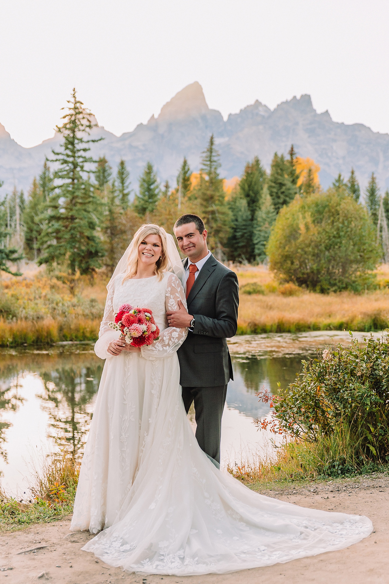 fall bridal portraits at Schwabacher Landing Jackson Hole Grand Teton National Park engagement photos String Lake bride in lace wedding dress with mountain backdrop Wyoming Schwabacher Landing fall color wedding photography Jackson Hole couple portraits with Snake River reflection bride and groom in fall foliage Grand Teton Wyoming rust orange tie groom wedding portraits Jackson Hole fall September engagement photos String Lake Teton National Park