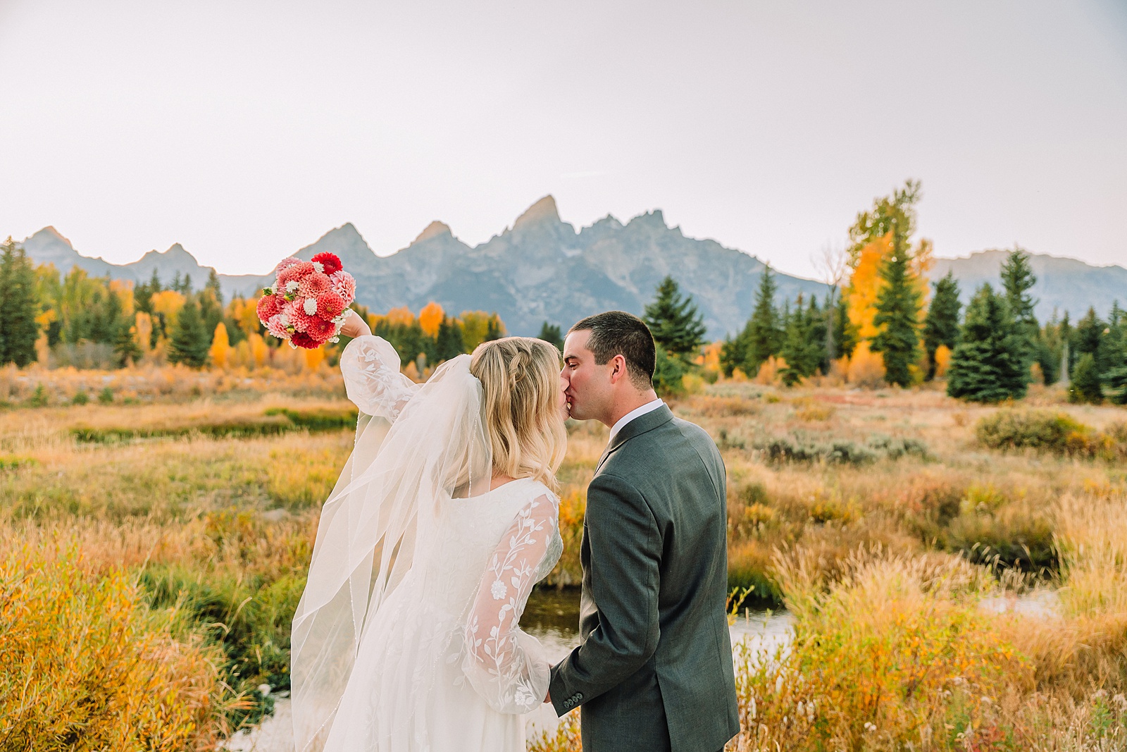 fall bridal portraits at Schwabacher Landing Jackson Hole Grand Teton National Park engagement photos String Lake bride in lace wedding dress with mountain backdrop Wyoming Schwabacher Landing fall color wedding photography Jackson Hole couple portraits with Snake River reflection bride and groom in fall foliage Grand Teton Wyoming rust orange tie groom wedding portraits Jackson Hole fall September engagement photos String Lake Teton National Park