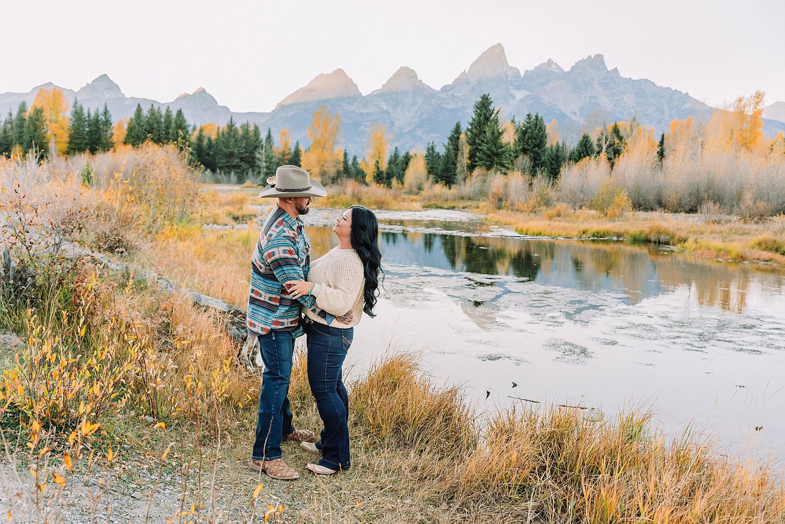 couple wearing custom engraved western hats at Grand Teton elopement turquoise wedding jewelry details at Jackson Hole mountain wedding horseback riding wedding party tour at Spring Creek Ranch Wyoming Schwabacher Landing sunset elopement portraits in Grand Teton National Park casual outfit change for relaxed mountain elopement photos split day wedding coverage for destination elopement couples flexible elopement timeline for Jackson Hole micro wedding western jeans and sweater look for Wyoming vacation style portraits