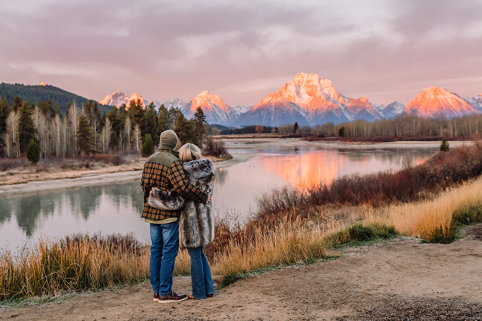 jackson hole anniversary photos at oxbow bend sunrise couple photography with fur coat jackson hole wyoming romantic river shoreline couples portraits grand teton national park october sunrise photography session oxbow bend