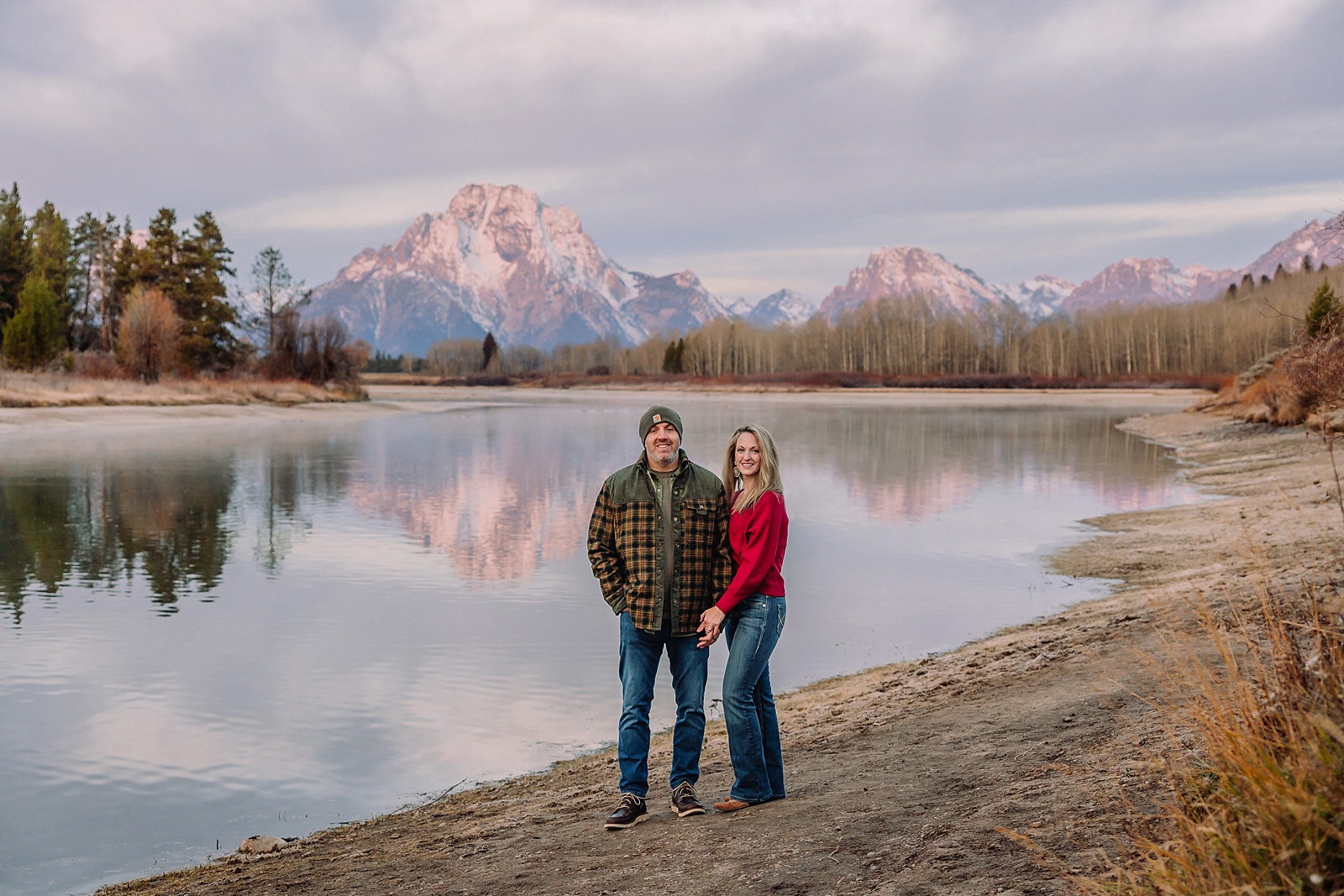 jackson hole anniversary photos at oxbow bend sunrise couple photography with fur coat jackson hole wyoming romantic river shoreline couples portraits grand teton national park october sunrise photography session oxbow bend