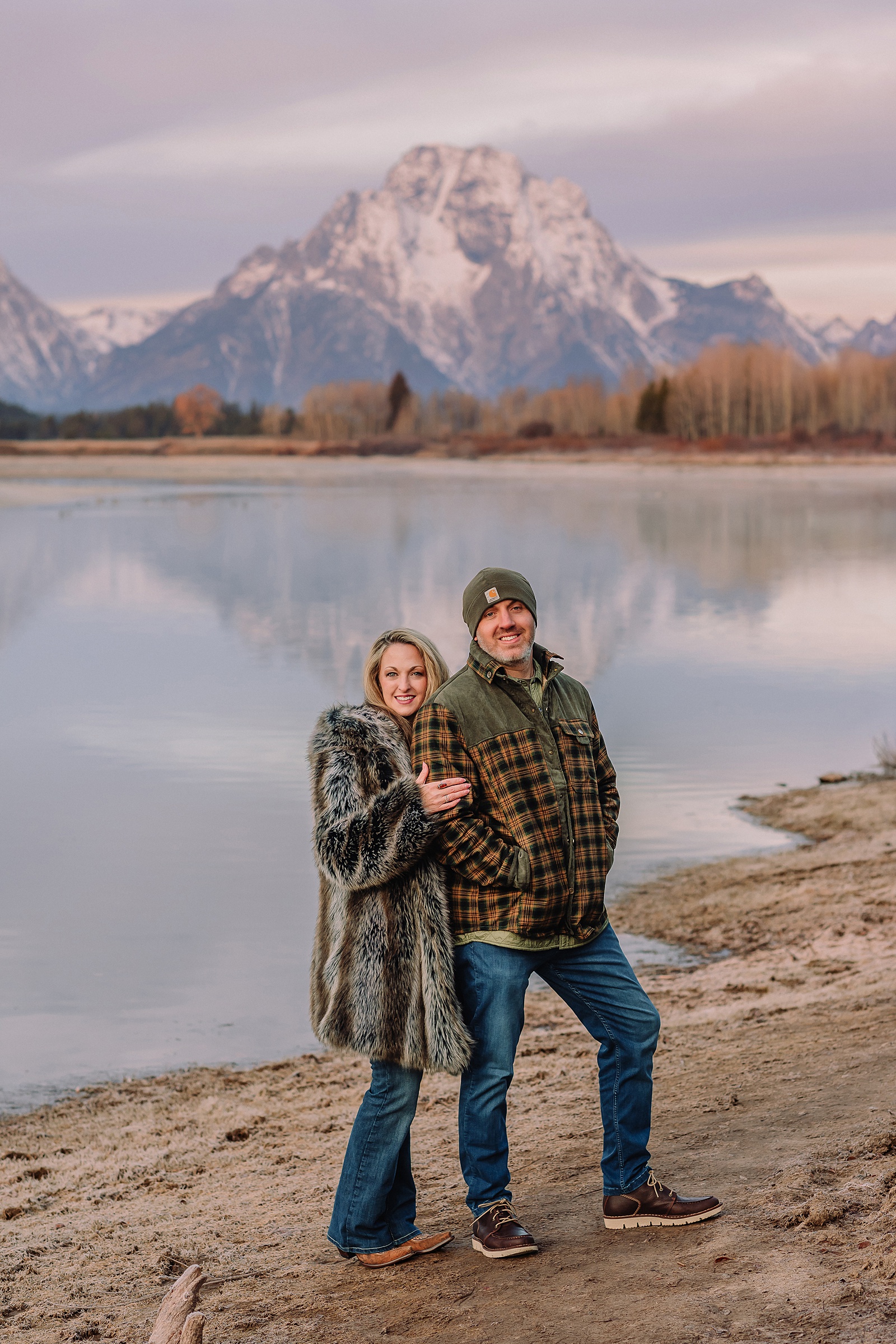 jackson hole anniversary photos at oxbow bend sunrise couple photography with fur coat jackson hole wyoming romantic river shoreline couples portraits grand teton national park october sunrise photography session oxbow bend