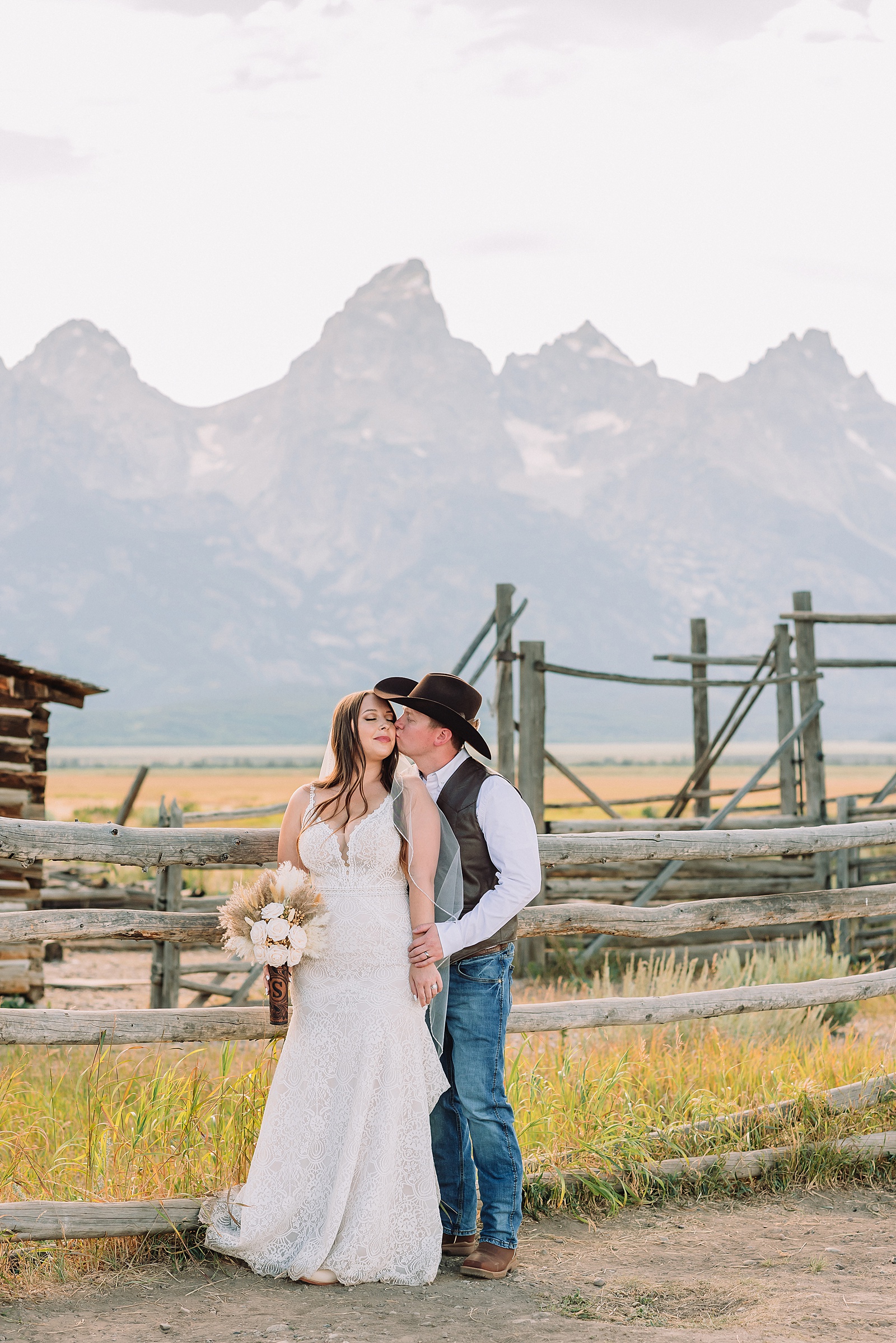 Jackson Hole wedding photographer barn photos Mormon Row western glam wedding dress deep neckline lace details mountain elopement with Teton backdrop intimate Jackson Hole wedding photography