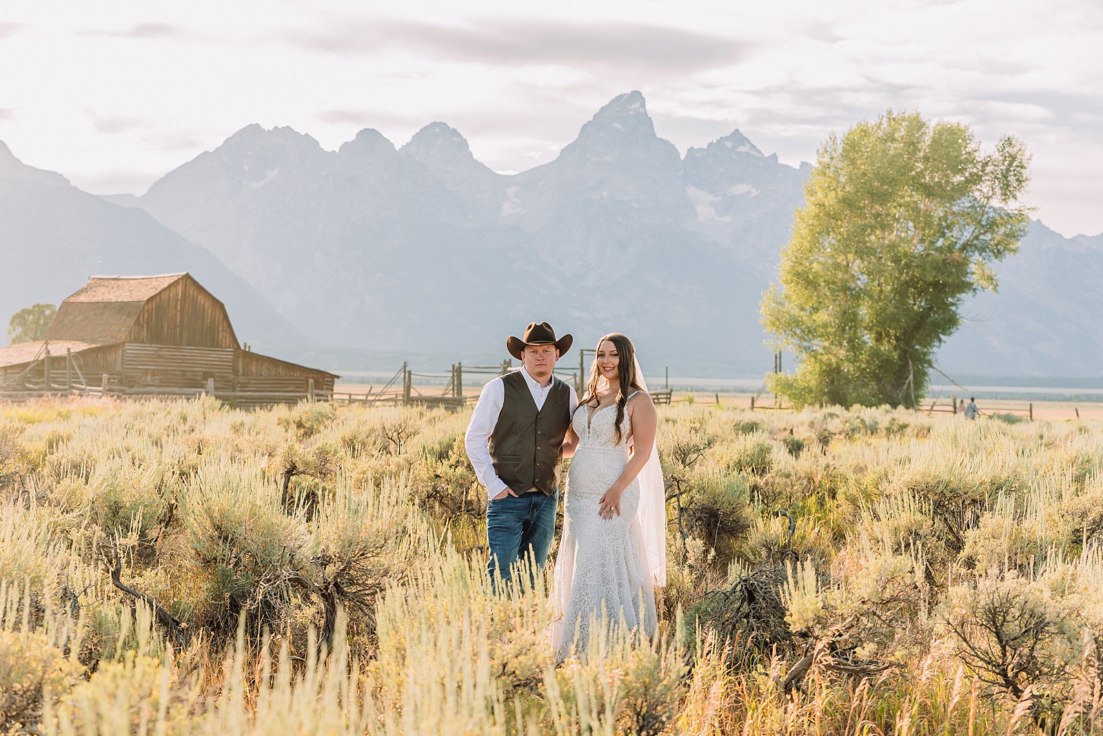 Jackson Hole wedding photographer barn photos Mormon Row western glam wedding dress deep neckline lace details mountain elopement with Teton backdrop intimate Jackson Hole wedding photography