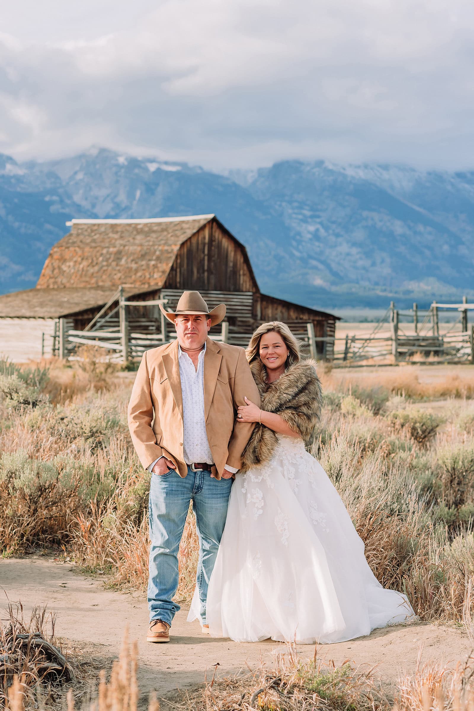 Mormon Row barn elopement photos with Grand Teton mountains fall elopement portraits at Mormon Row historic barns bride in fur wrap at Mormon Row Grand Teton cowboy hat groom Mormon Row wedding photos Schwabacher Landing elopement reflection photos