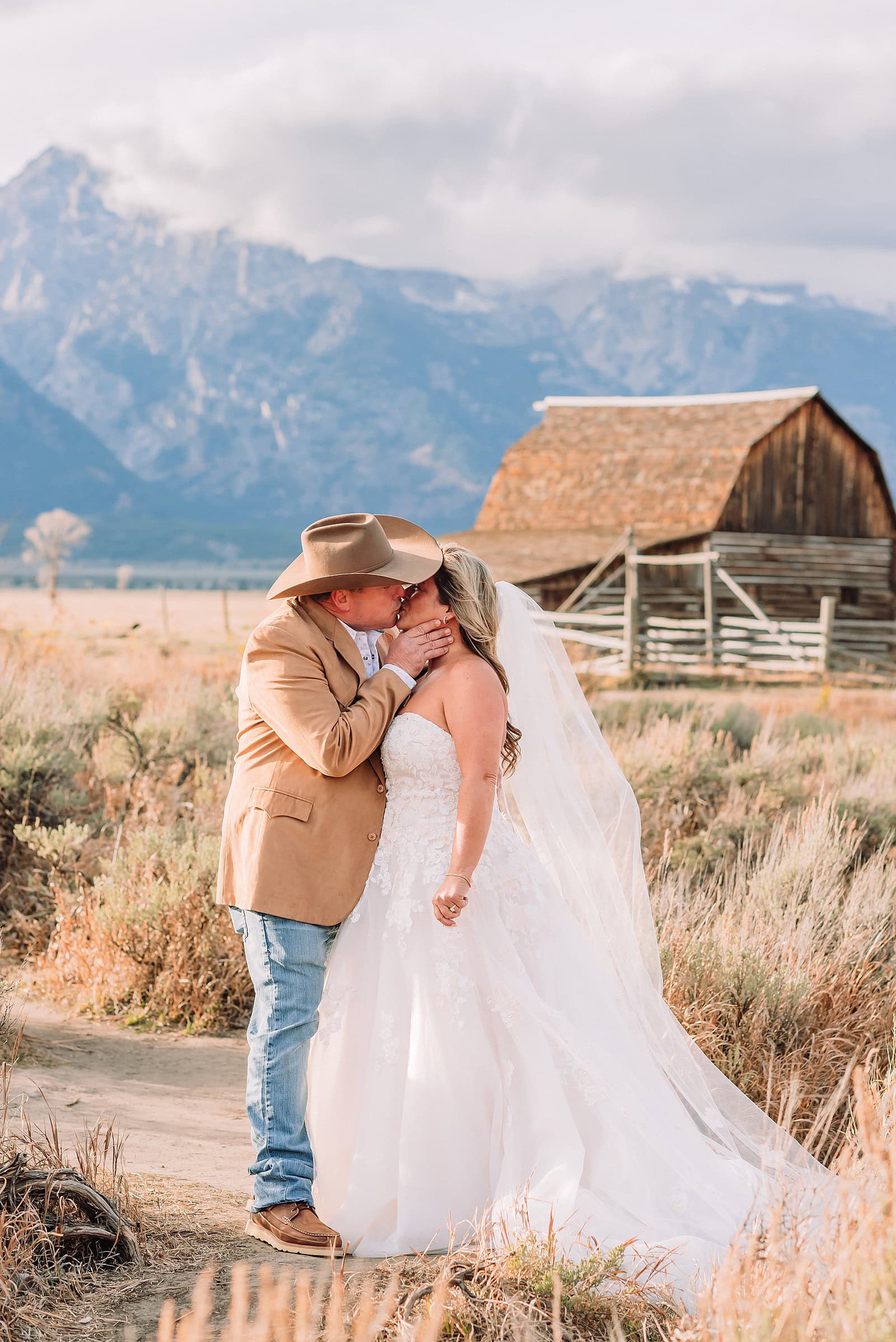 Mormon Row barn elopement photos with Grand Teton mountains fall elopement portraits at Mormon Row historic barns bride in fur wrap at Mormon Row Grand Teton cowboy hat groom Mormon Row wedding photos Schwabacher Landing elopement reflection photos