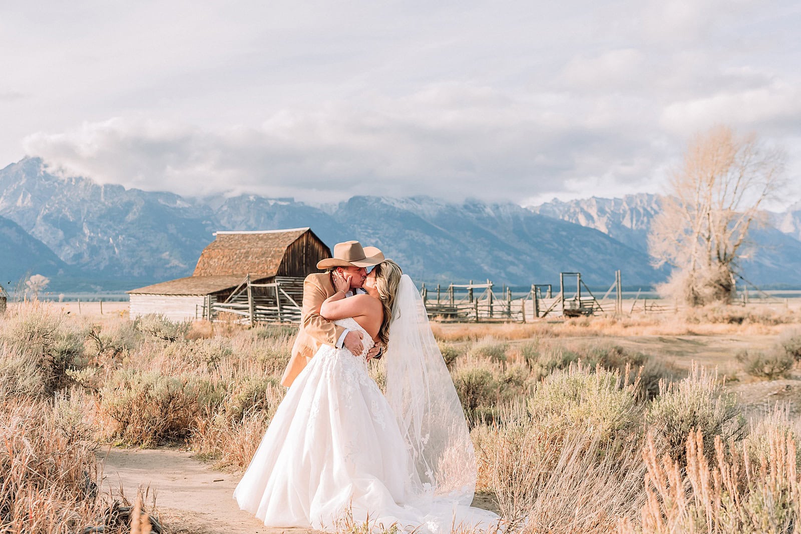 Mormon Row barn elopement photos with Grand Teton mountains fall elopement portraits at Mormon Row historic barns bride in fur wrap at Mormon Row Grand Teton cowboy hat groom Mormon Row wedding photos Schwabacher Landing elopement reflection photos
