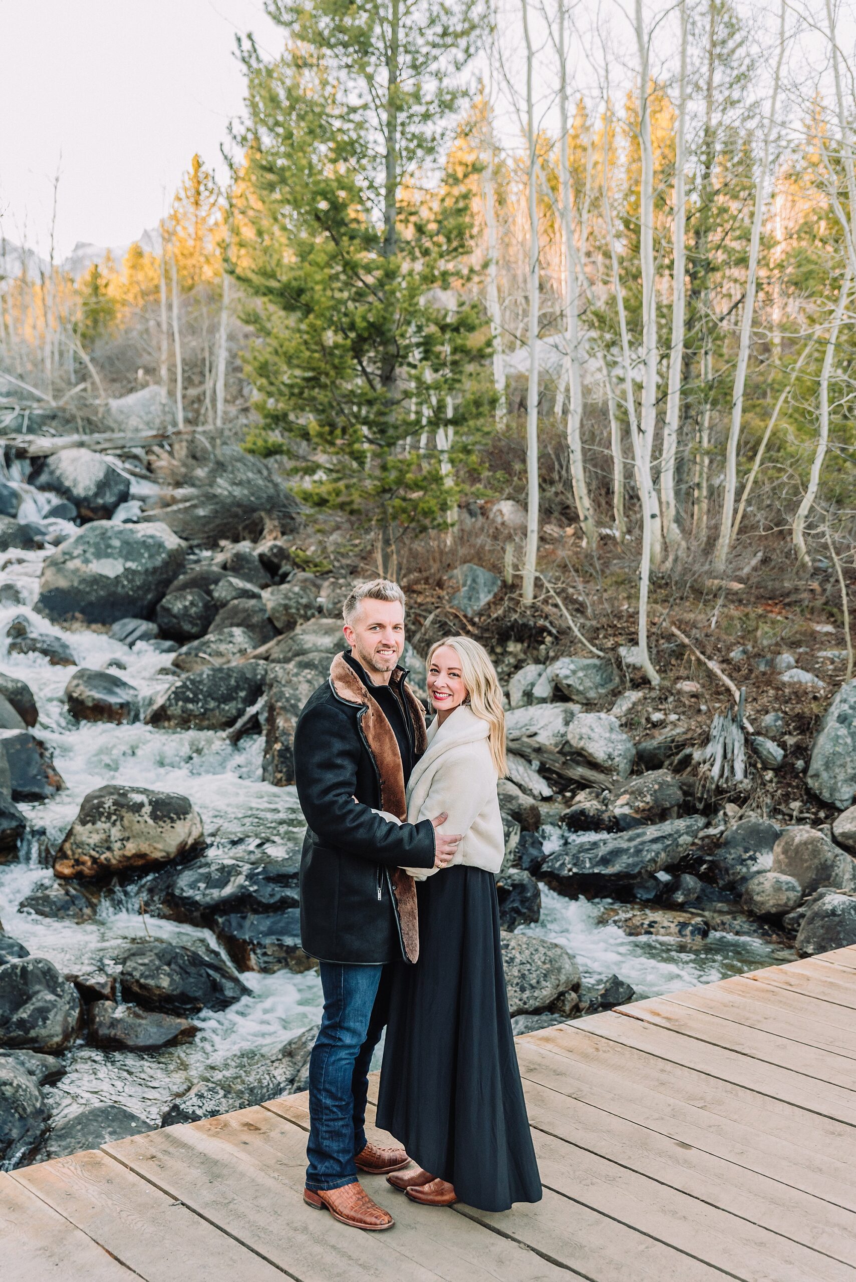 Taggart Lake engagement photography Jackson Hole Wyoming Grand Teton couples anniversary photos spring session Wyoming mountain bridge waterfall couple portraits Luxury western couples photography Jackson Hole Early season mountain engagement photos Tetons