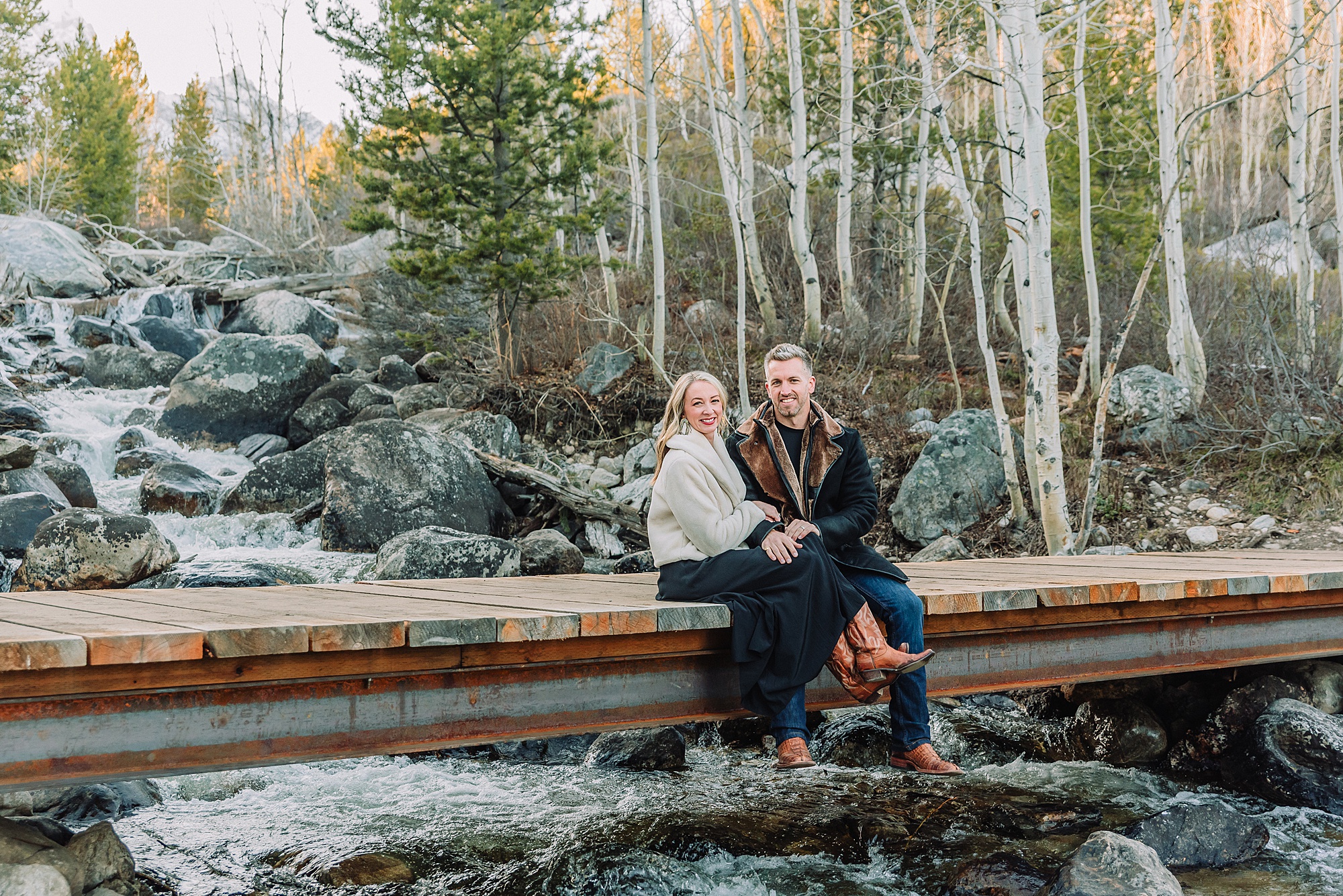 Luxury western couples photography Jackson Hole Early season mountain engagement photos Tetons Taggart Lake trailhead anniversary photography session Cascade bridge couples portraits Grand Teton National Park Faux fur coat mountain couples photoshoot Wyoming