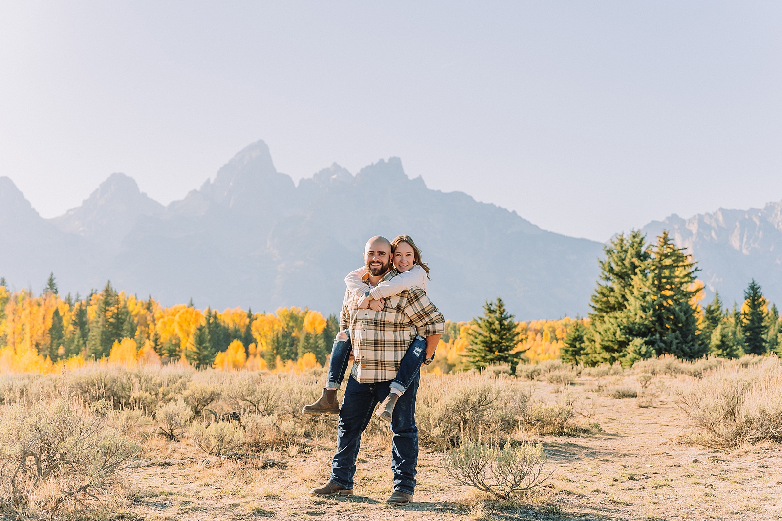 Casual mountain engagement photos with jeans Fall engagement session Grand Tetons Wyoming Cream sweater engagement photos mountain backdrop September Teton engagement photography golden hour Candid mountain couple photos engagement session