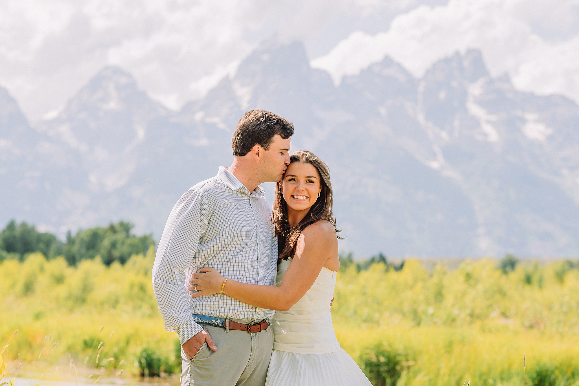 summer engagement photos at Schwabacher Landing Wyoming mountain engagement session with river views Grand Tetons white dress engagement photos in nature Teton mountain backdrop engagement photography outdoor engagement photos with cloudy blue skies