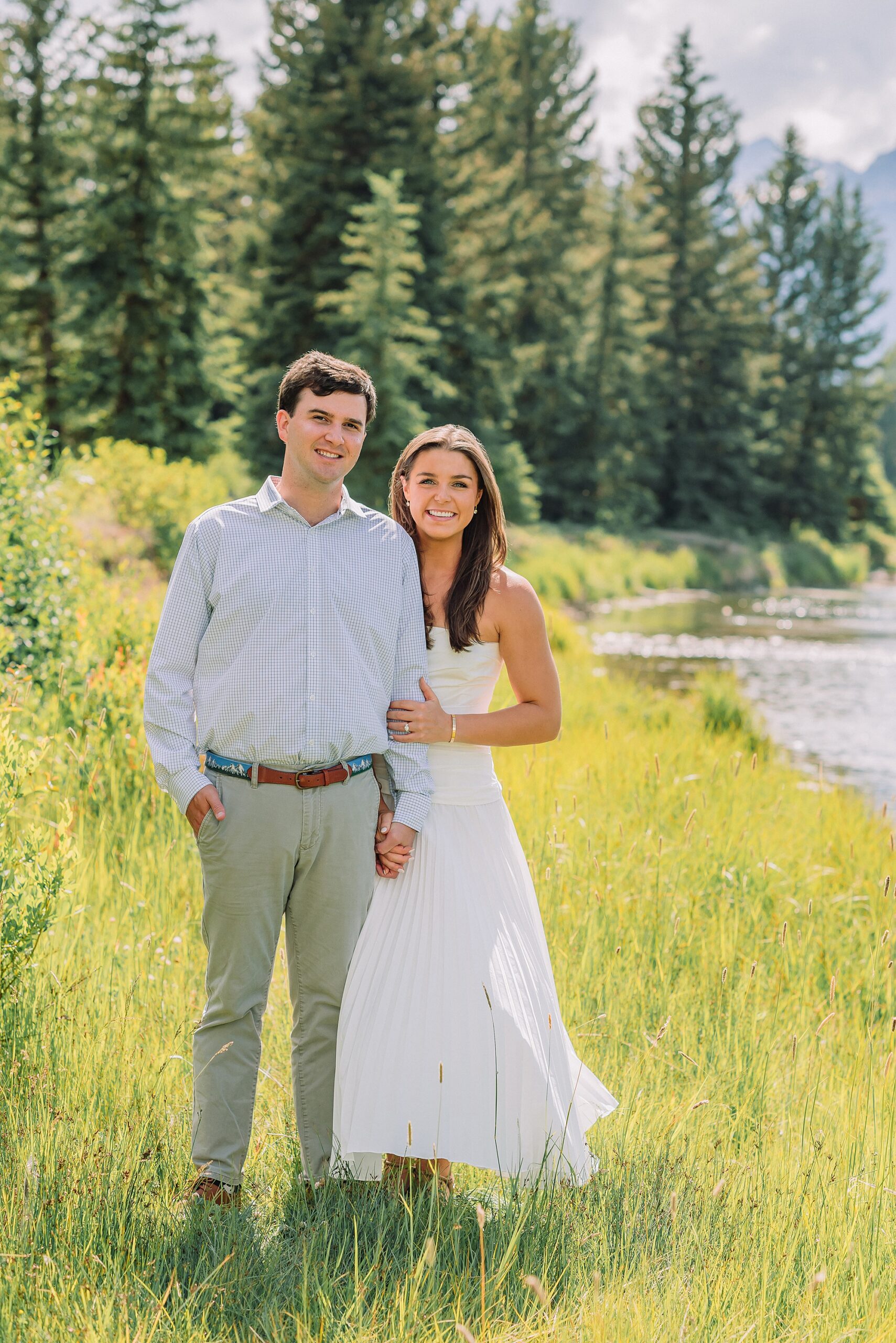 summer engagement photos at Schwabacher Landing Wyoming mountain engagement session with river views Grand Tetons white dress engagement photos in nature Teton mountain backdrop engagement photography outdoor engagement photos with cloudy blue skies