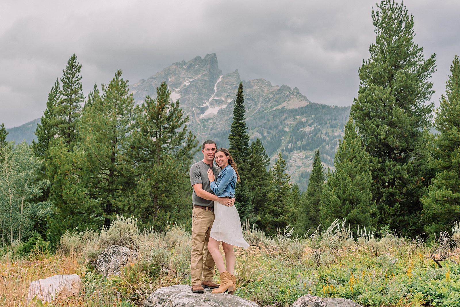 outdoor family photographer Teton mountains Wyoming Jenny Lake engagement photos windy conditions Mountain View Turnout couple portraits Grand Tetons Teton Glacier Turnout western family photos Grand Teton vacation photographer coordinating family outfits without matching