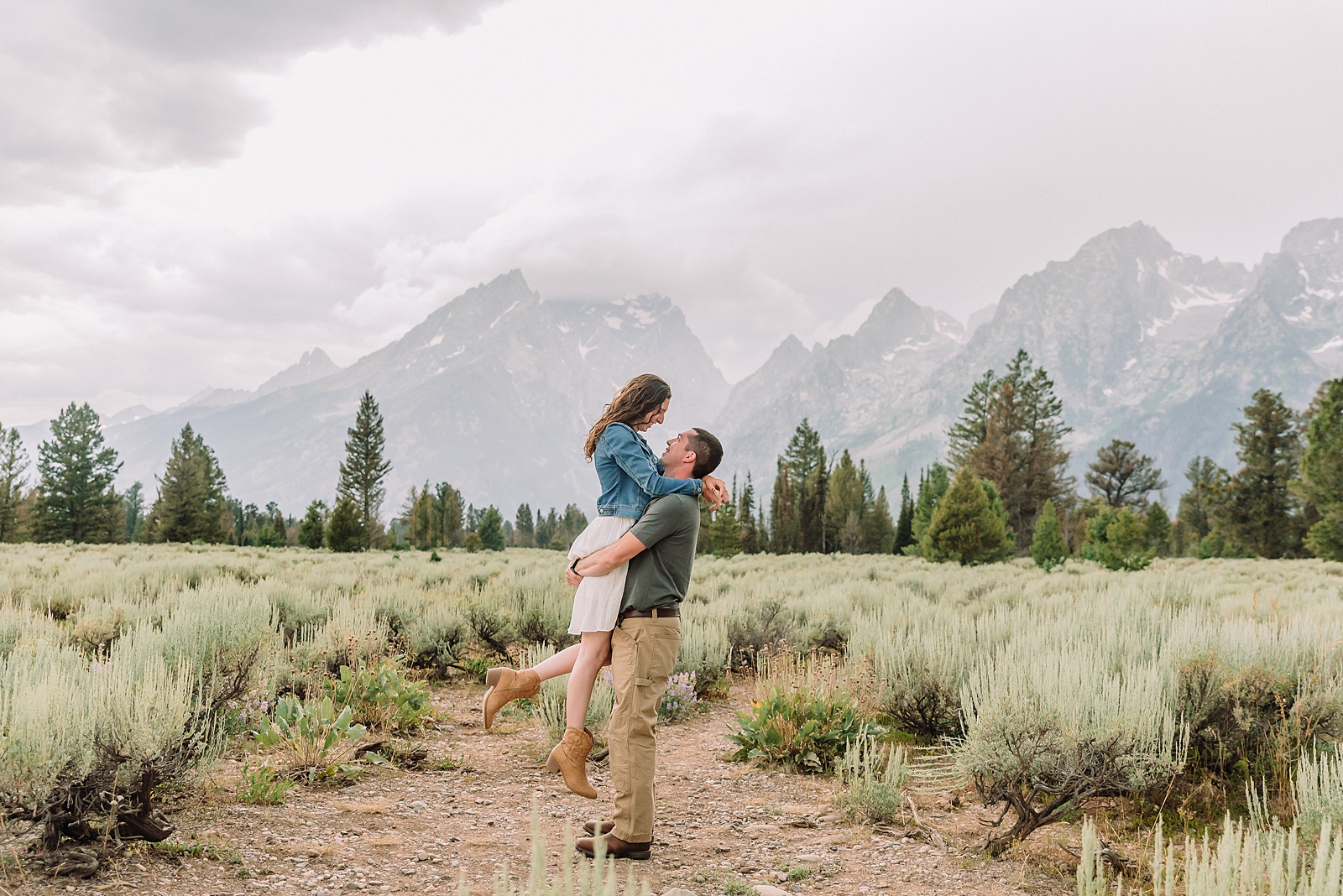 outdoor family photographer Teton mountains Wyoming Jenny Lake engagement photos windy conditions Mountain View Turnout couple portraits Grand Tetons Teton Glacier Turnout western family photos Grand Teton vacation photographer coordinating family outfits without matching