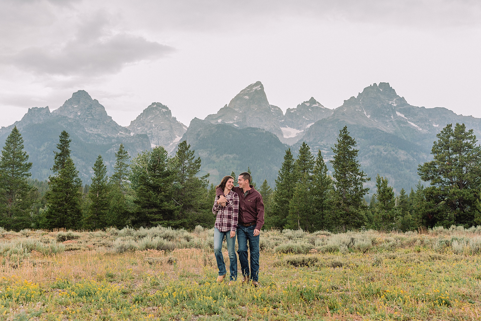outdoor family photographer Teton mountains Wyoming Jenny Lake engagement photos windy conditions Mountain View Turnout couple portraits Grand Tetons Teton Glacier Turnout western family photos Grand Teton vacation photographer coordinating family outfits without matching